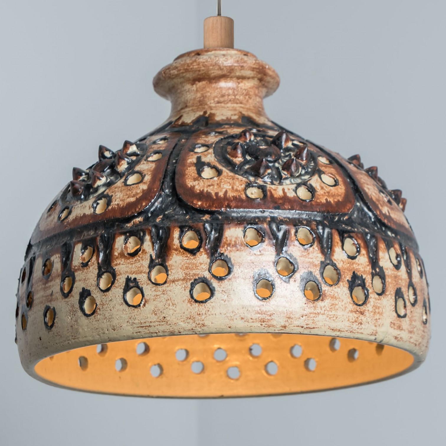 Juguetona disposición de impresionantes lámparas colgantes redondas con una forma inusual, hechas con cerámica marrón de ricos colores, fabricadas en la década de 1970 en Dinamarca. Tenemos multitud de conjuntos y arreglos de luces de cerámica de
