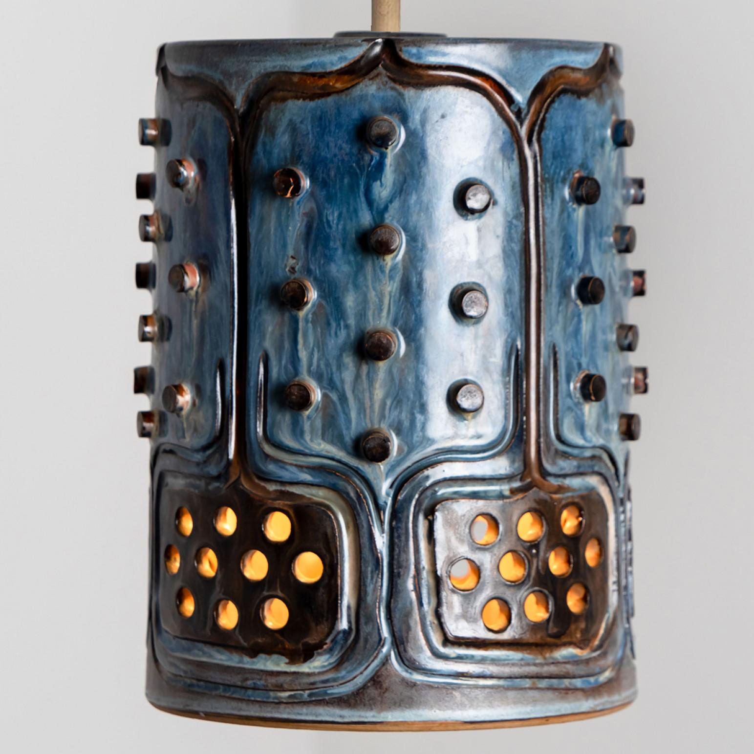 Playful arrangement of stunning round hanging lamps with an unusual shape, made with rich blue colored brown ceramics, manufactured in the 1970s in Denmark. We have a multitude of unique colored ceramic light sets and arrangements, all available in