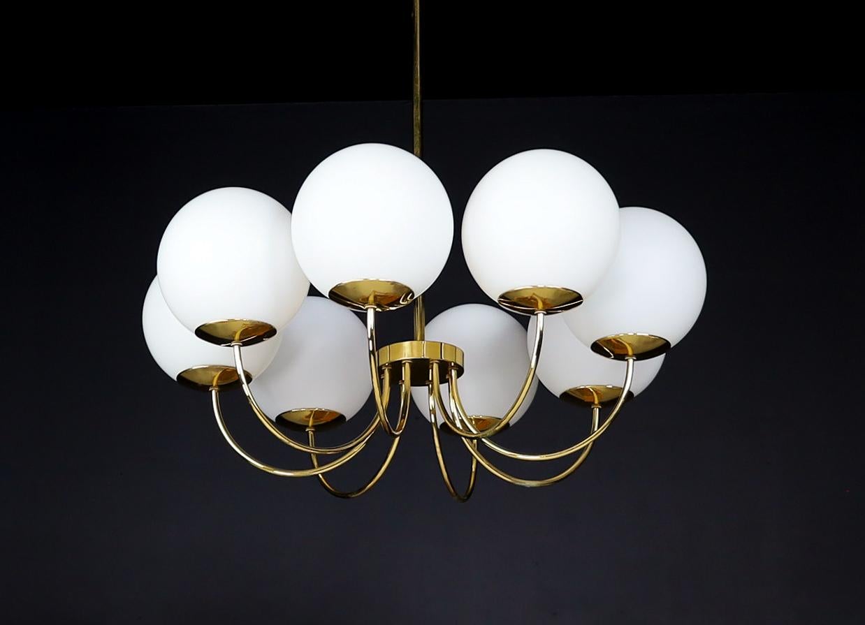 Elegant chandelier with brass fixture and opaline glass globes, Italy 1960s

A large chandelier with a brass fixture was produced and designed in Italy in the 1960s. A total of eight large opaline globes formed in a circle. The pleasant light it