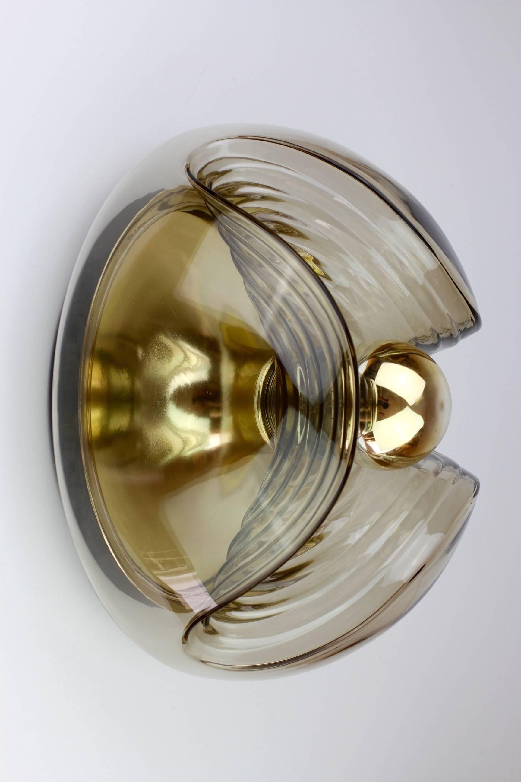 One of a set of three midcentury flushmount wall lights or sconces designed by Koch & Lowy for Peill & Putzler in the 1970s. This is an absolutely Classic piece of design, featuring a smoked colored (colored) glass globe shade with a waved/ribbed