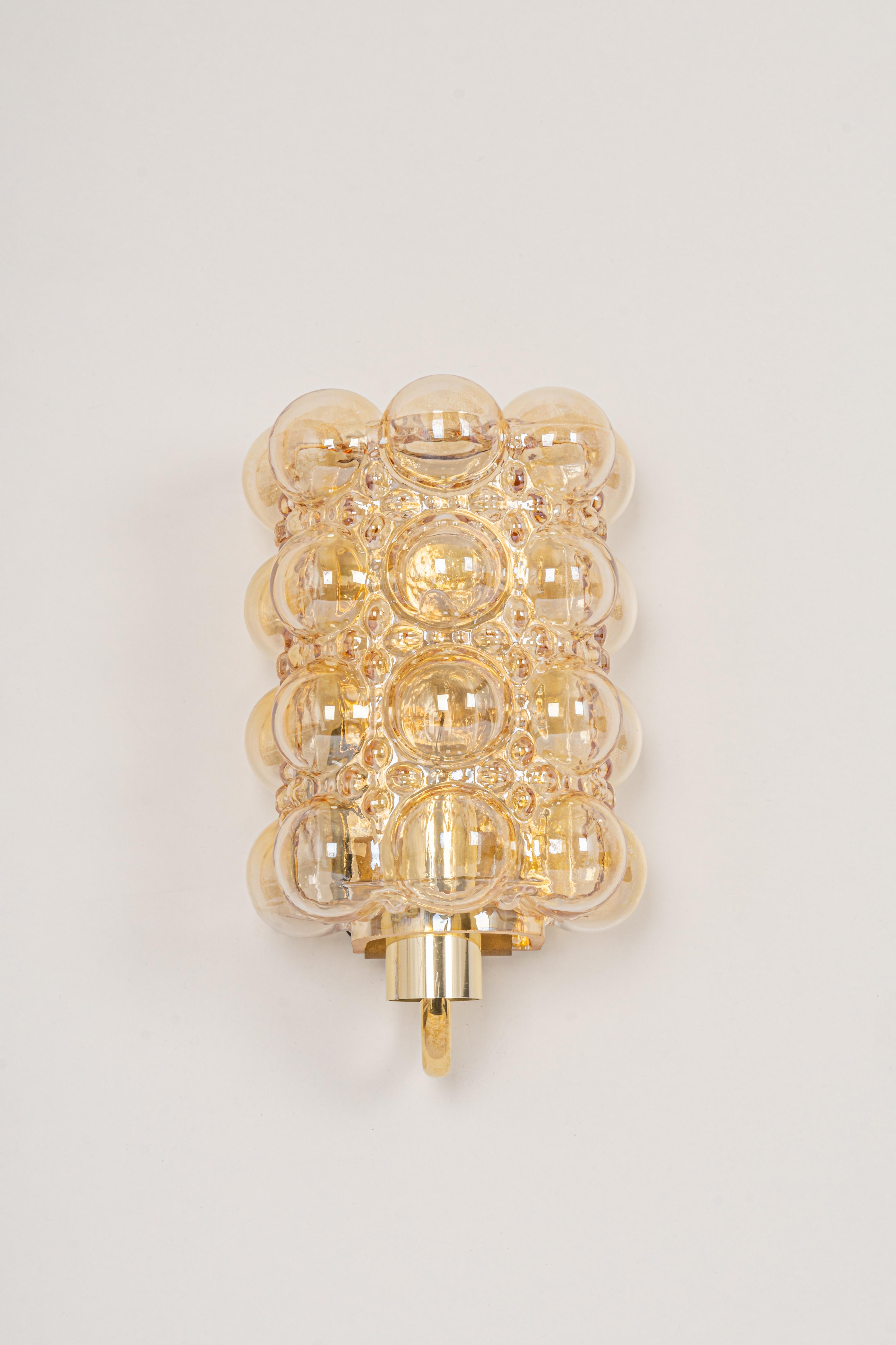 Wonderful golden wall lights, from Limburg Glashütte, Germany, circa 1960-1970. Smoked bubble glasses on a golden brass base.


Heavy quality and in very good condition. Cleaned, well-wired and ready to use.
For each sconce: 1 x E27 Standard