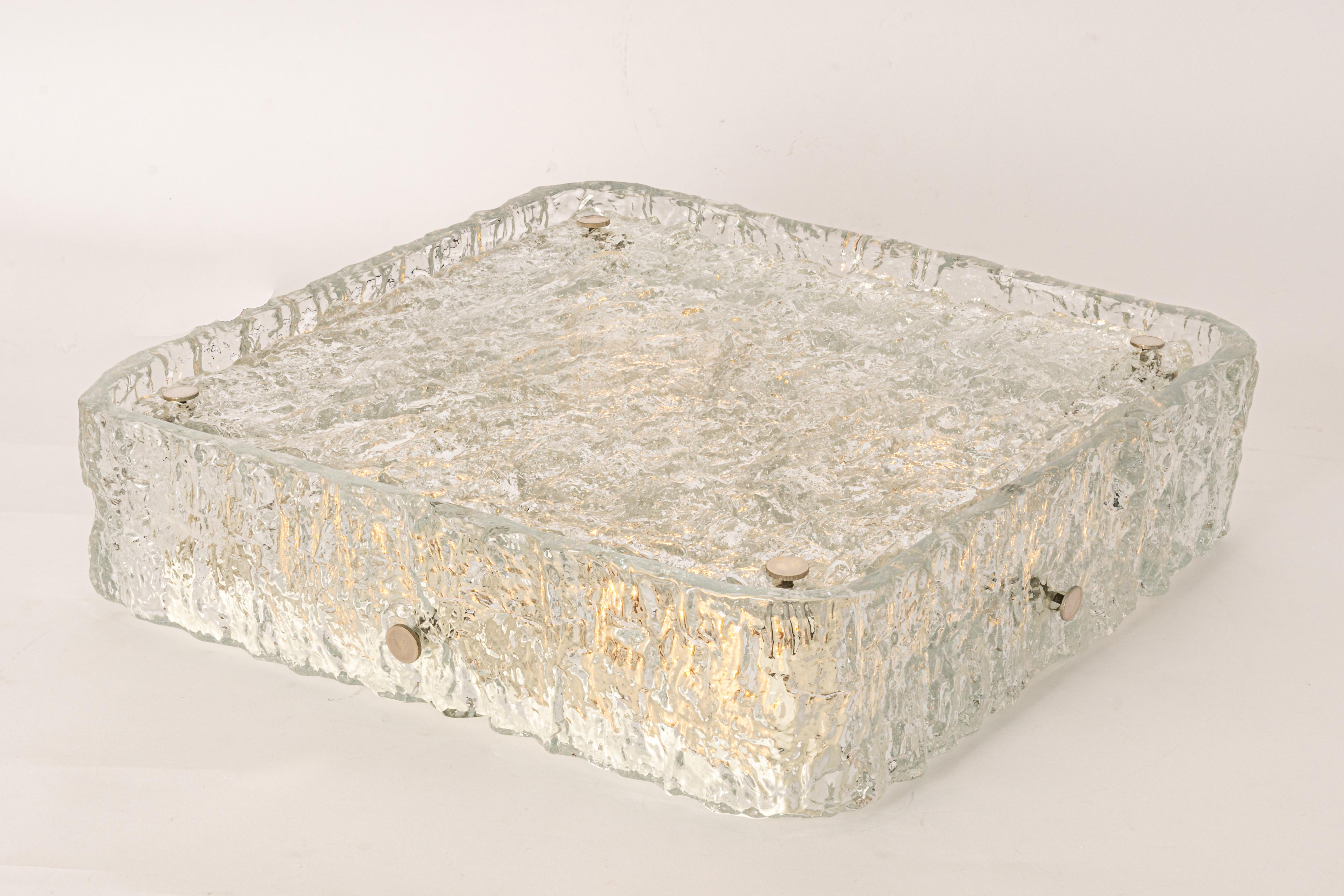 A stunning large square Murano ice glass flush mount made by Kaiser Leuchten in Germany during the 1970s. This exquisite piece features thickly textured Murano glass mounted on a white metal base with eight chrome holders, showcasing exceptional