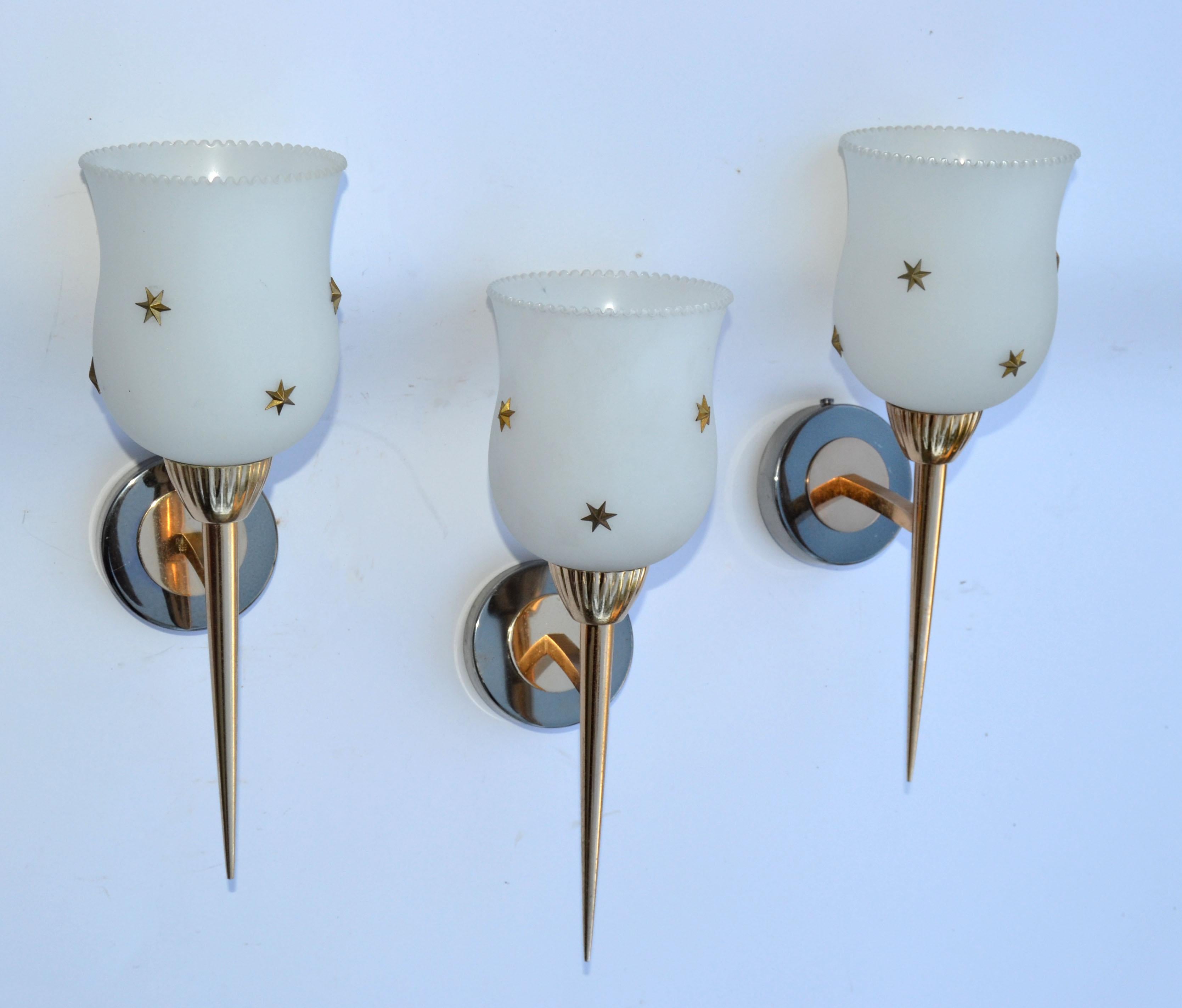  5 Maison Arlus 2 Patina Brass Sconces, wall lights with original Brass Stars decorated white blown Opaline glass shade.
Perfect working condition and each sconce takes one bulb max. 60 watts.
Back Plate Diameter measures: 2.75 inches. 
Opaline