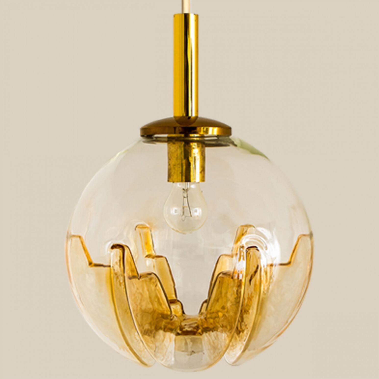 A collection of beautiful and stylish glass pendant lights made in Germany and Italy around the 1960's. The Doria light is made of yellow clear glass in a bubble shape. The Kaiser light is made of clear red-brown glass and the Mazzega light is
