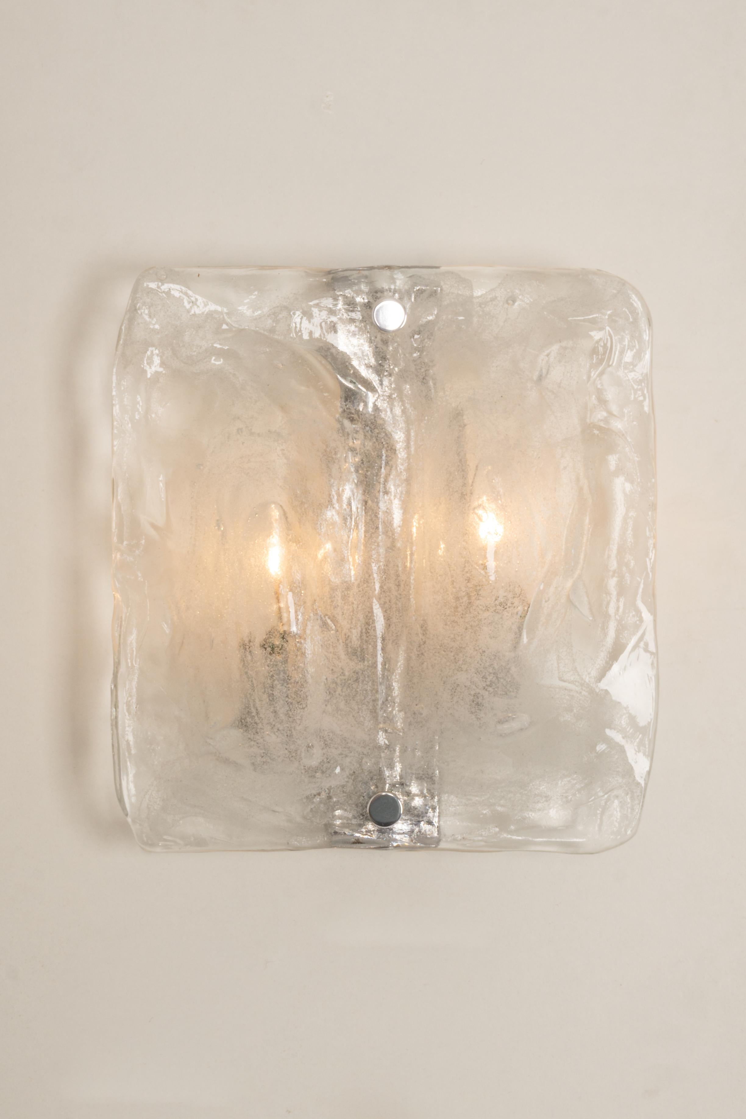 Wonderful pair of midcentury wall sconces with one large Murano glass piece in each lamp, made by Kalmar, Austria, manufactured, circa 1960-1969.
Chrome metal base.
High quality and in very good condition. Cleaned, well-wired, and ready to