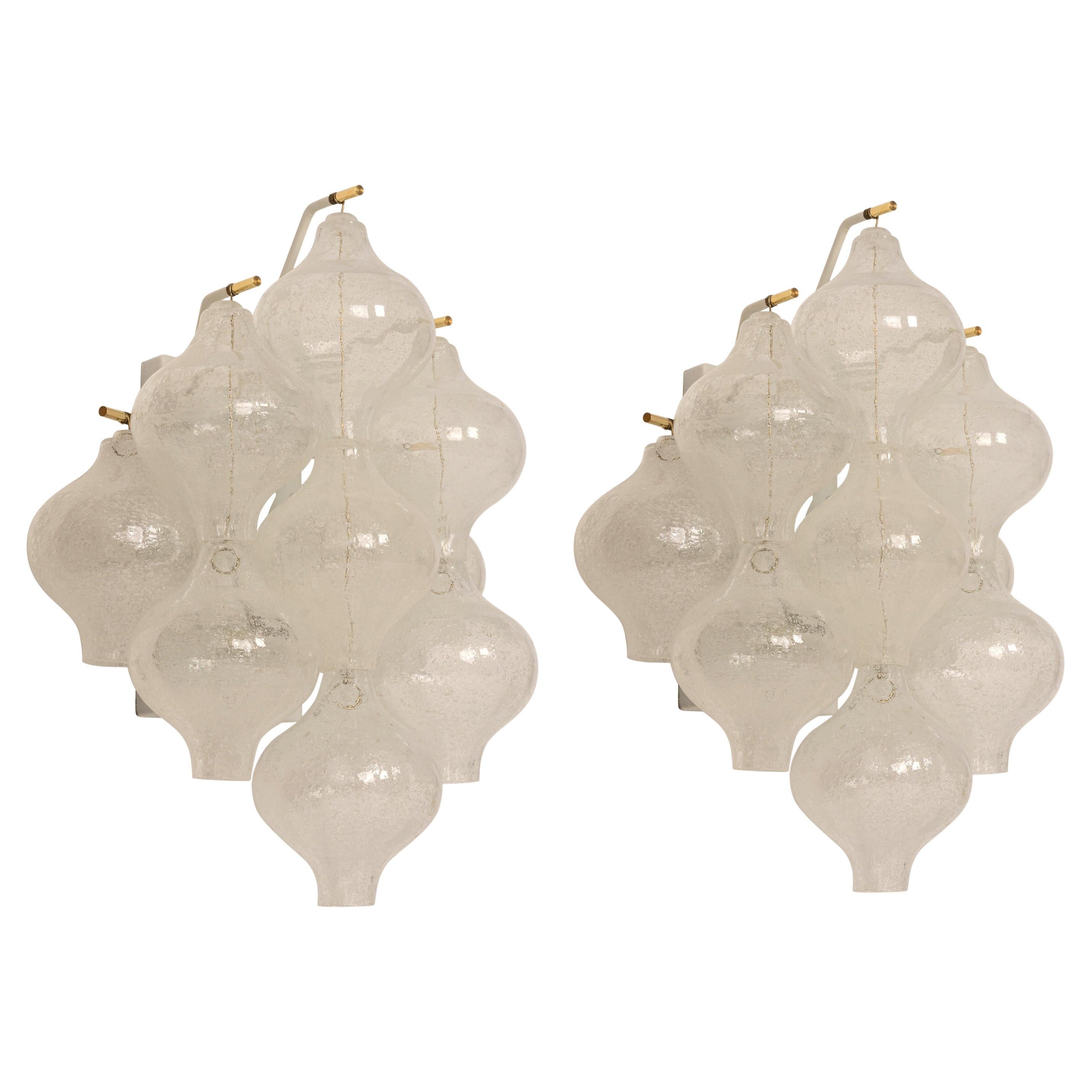Wonderful pair of midcentury wall sconces, made by Kalmar, Austria, manufactured, circa 1970-1979.
Each tulip-shaped glass is handmade which makes each glass piece a unique piece. Each sconce is made of 7 glass pieces on a white enameled metal