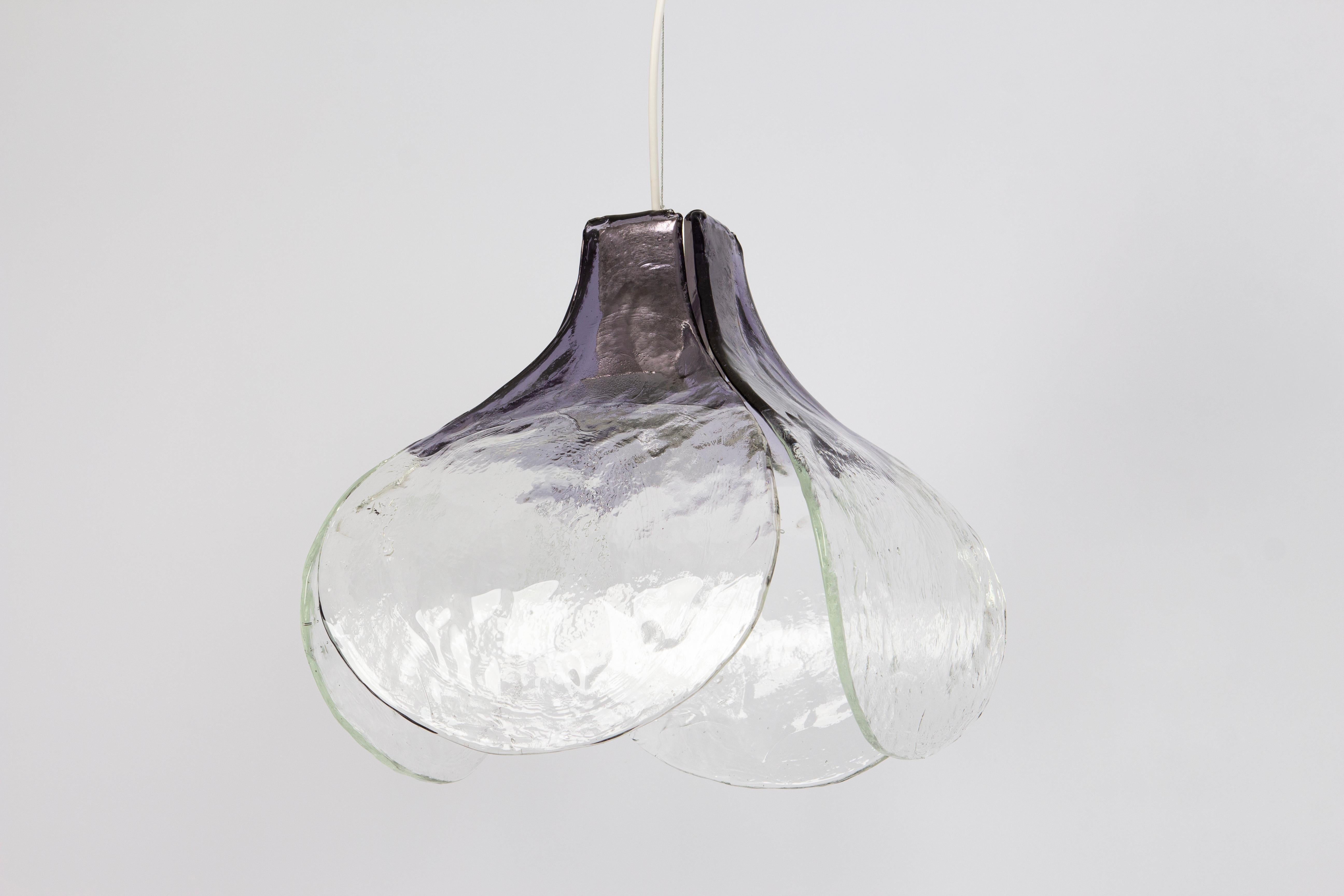 Splendida lampada a sospensione floreale con quattro petali in vetro di Murano trasparente e fumé realizzati a mano e sostenuti da una struttura in metallo, disegnata da Carlo Nason per Kalmar, negli anni '70.

Di qualità pesante e in ottime