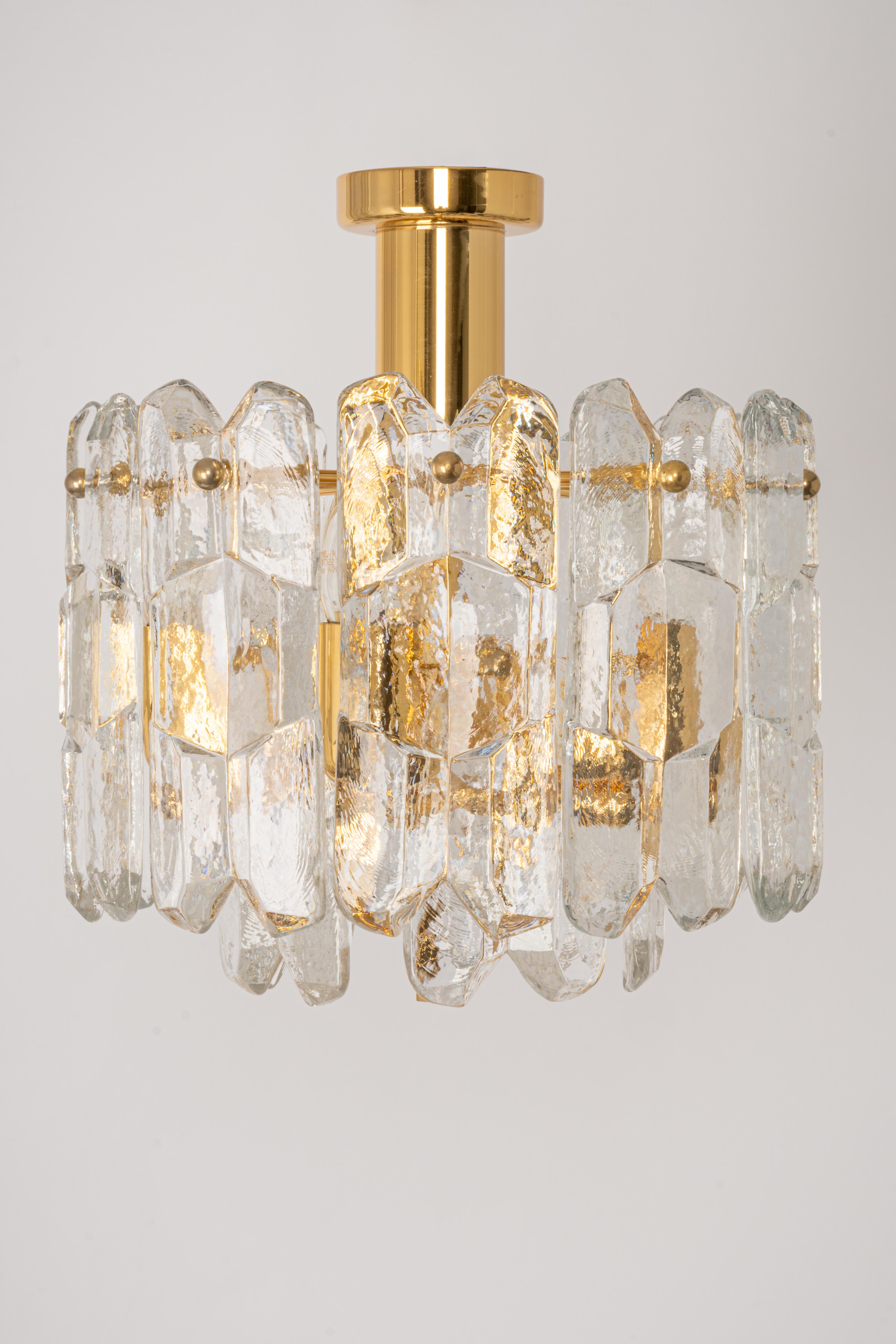 A Wonderful gilt brass light fixture comprises 15 crystal Murano glass pieces on a gilded brass frame. Its made by Kalmar (Serie: Palazzo), Austria, manufactured circa 1970-1979.

Two tiers structure gathers many structured glasses, beautifully
