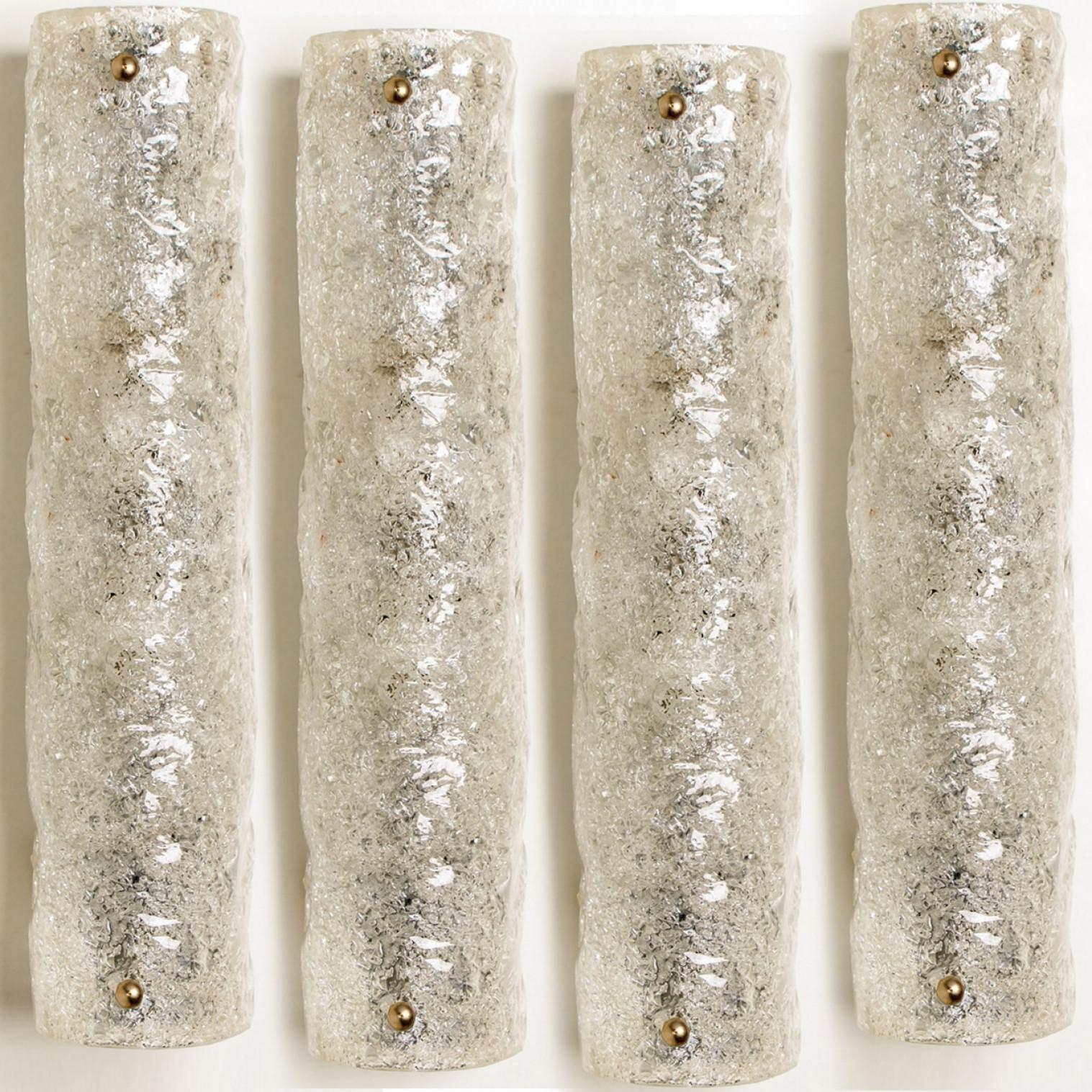Clean lines to complement all decors. Wonderful high-end wall light fixtures with brass detail and thick bubbled blown ice glass. Manufactured in the 1960s.
The glass of the light fixtures are made of ice glass giving the piece a heavy ice