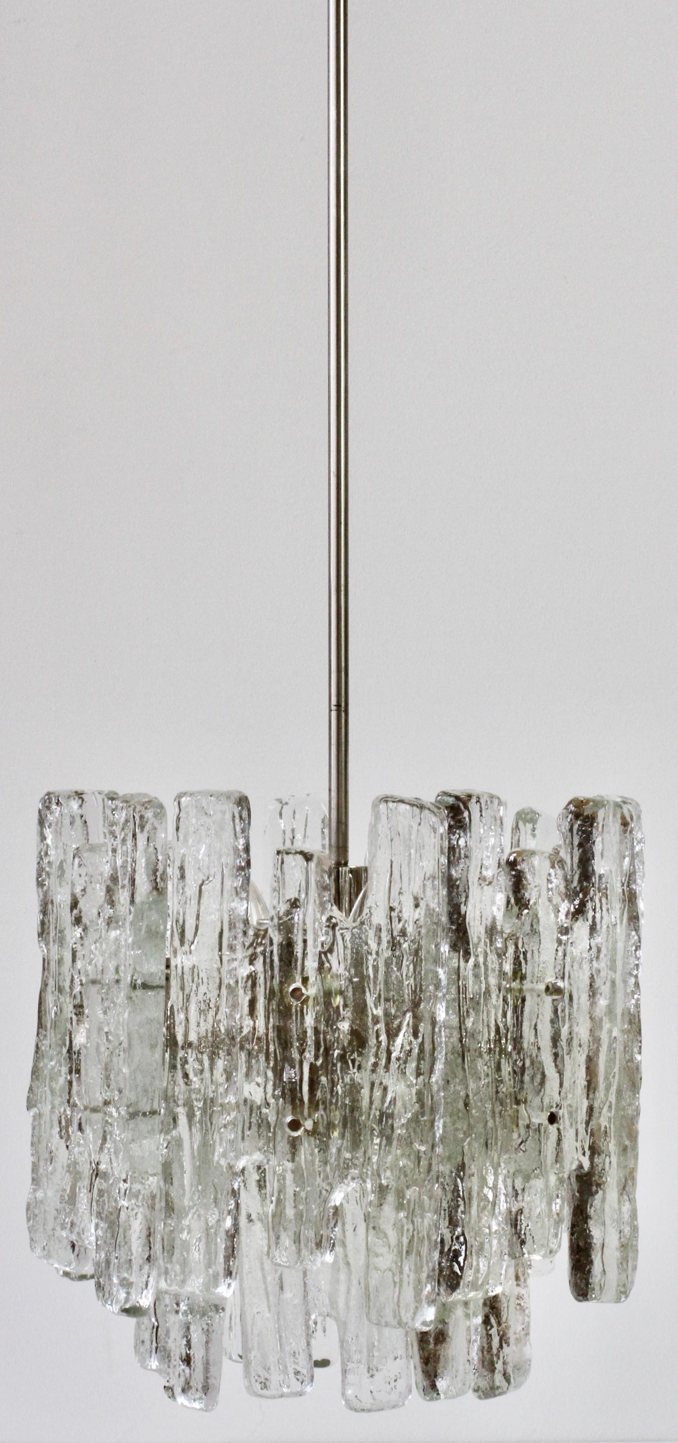 One of a pair of vintage midcentury Austrian made textured clear ice glass ceiling pendant lights / lamps or chandeliers by Kalmar, circa 1974. Featuring twelve hanging glass elements (six large & six small) resembling melting ice crystals suspended