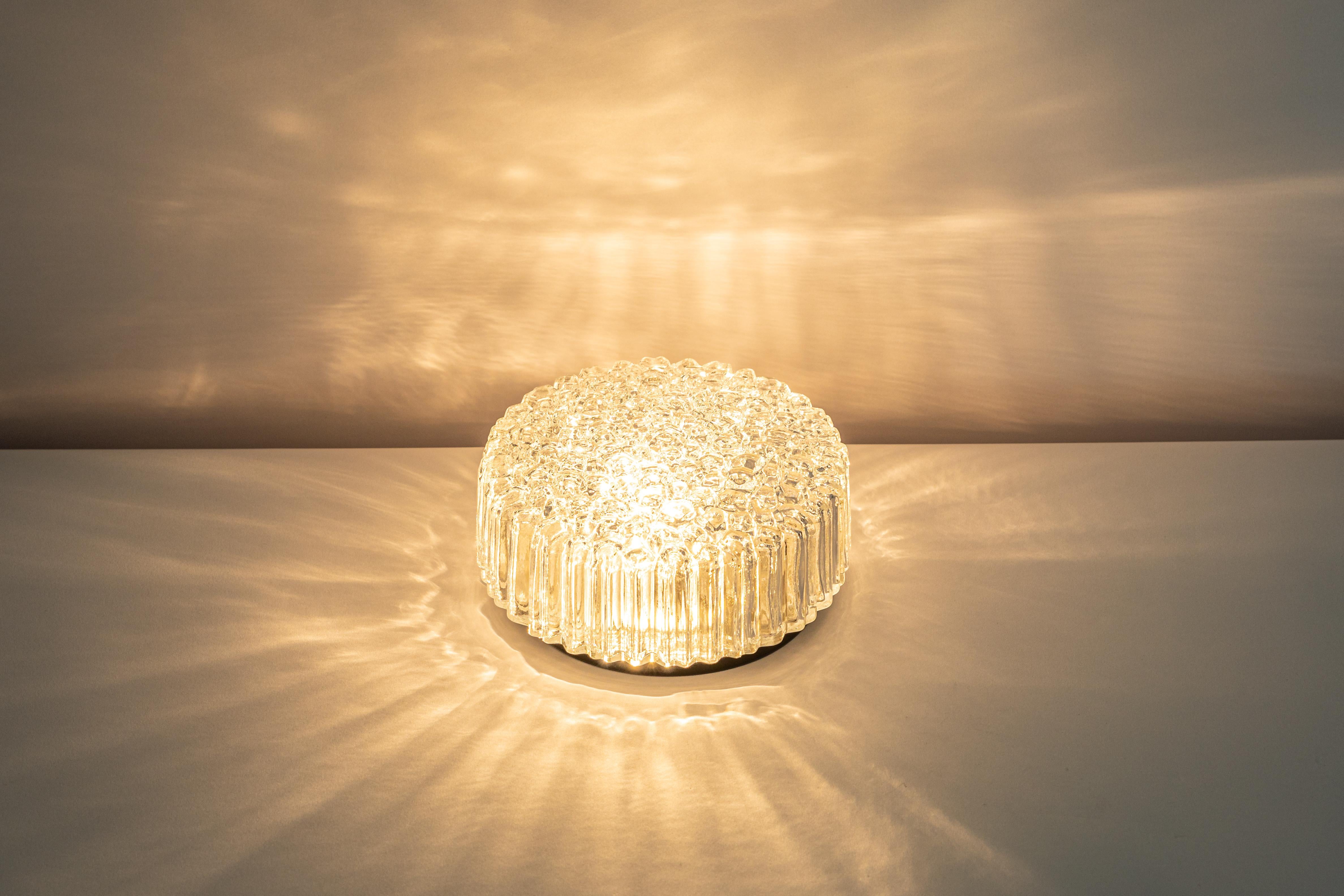 1 of 4 wonderful round glass wall lights by Limburg, Germany, 1970s.
Thick textured Glass fixtured on a black metal base.

Good quality and condition. Cleaned, well-wired, and ready to use. 

Each fixture requires 1 x E27 standard bulbs with