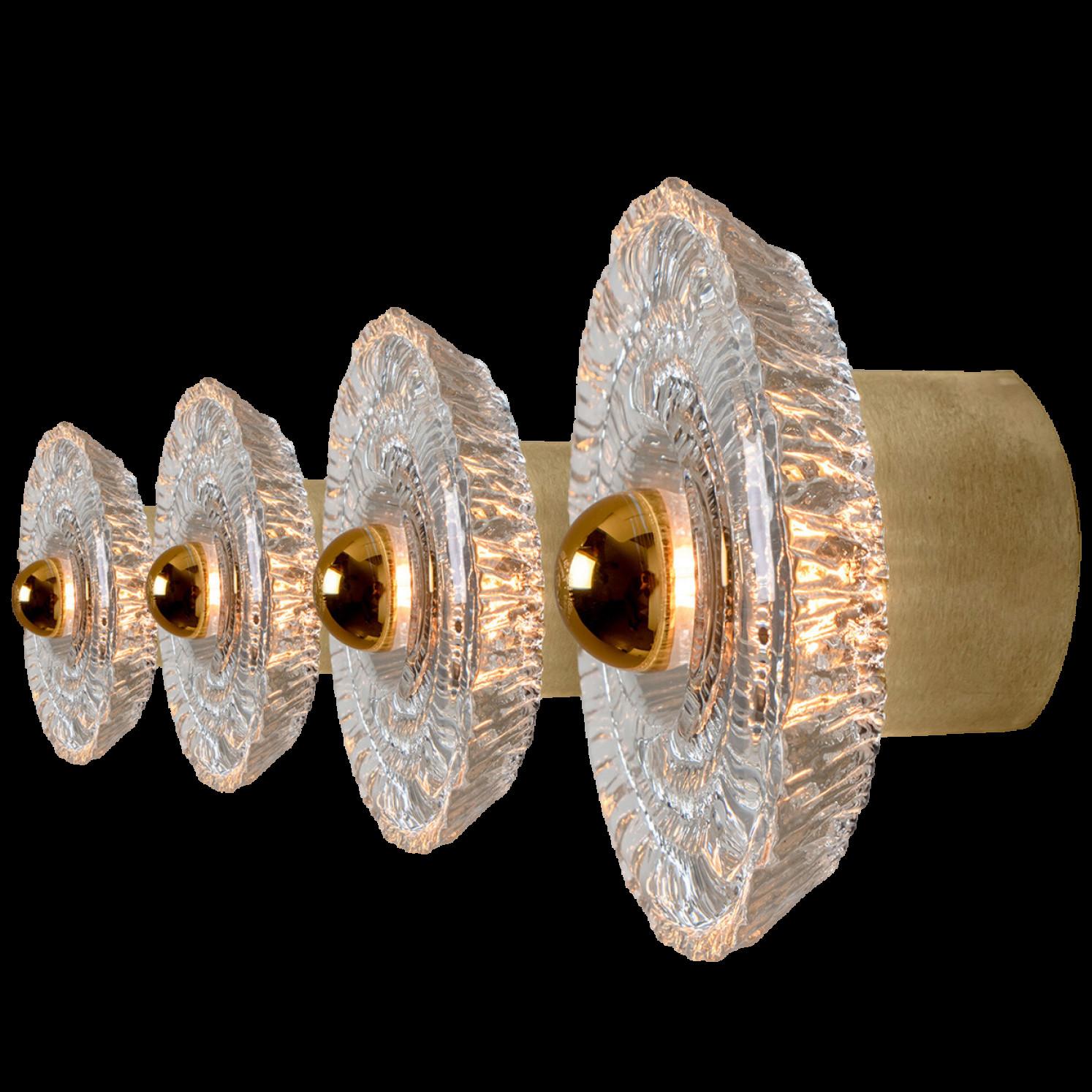 Four beautiful mid-20th century wall lights by Peill & Putzler. Made around 1970 in Germany, Europe. Featuring a large clear glass shade with gold around it. The light illuminates wonderful.

The lights can also be used as flush mounts.

Please note