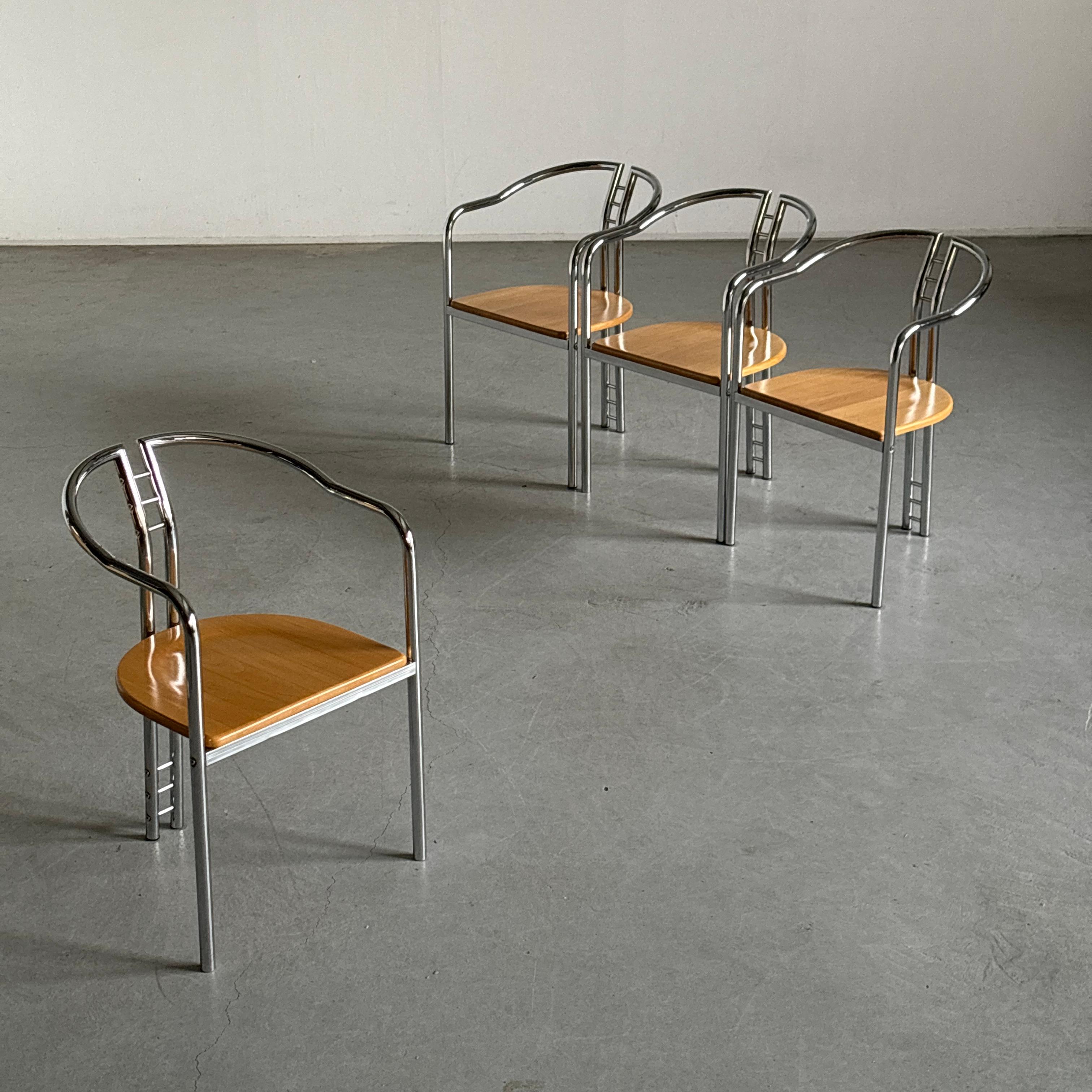 Four vintage postmodern armchairs featuring a beechwod seat resting on a sculptural chromed steel frame.

Manufactured in Italy in the 1980s.

In good vintage condition with expected signs of age. Some scratching and slight oxidation on the chromed