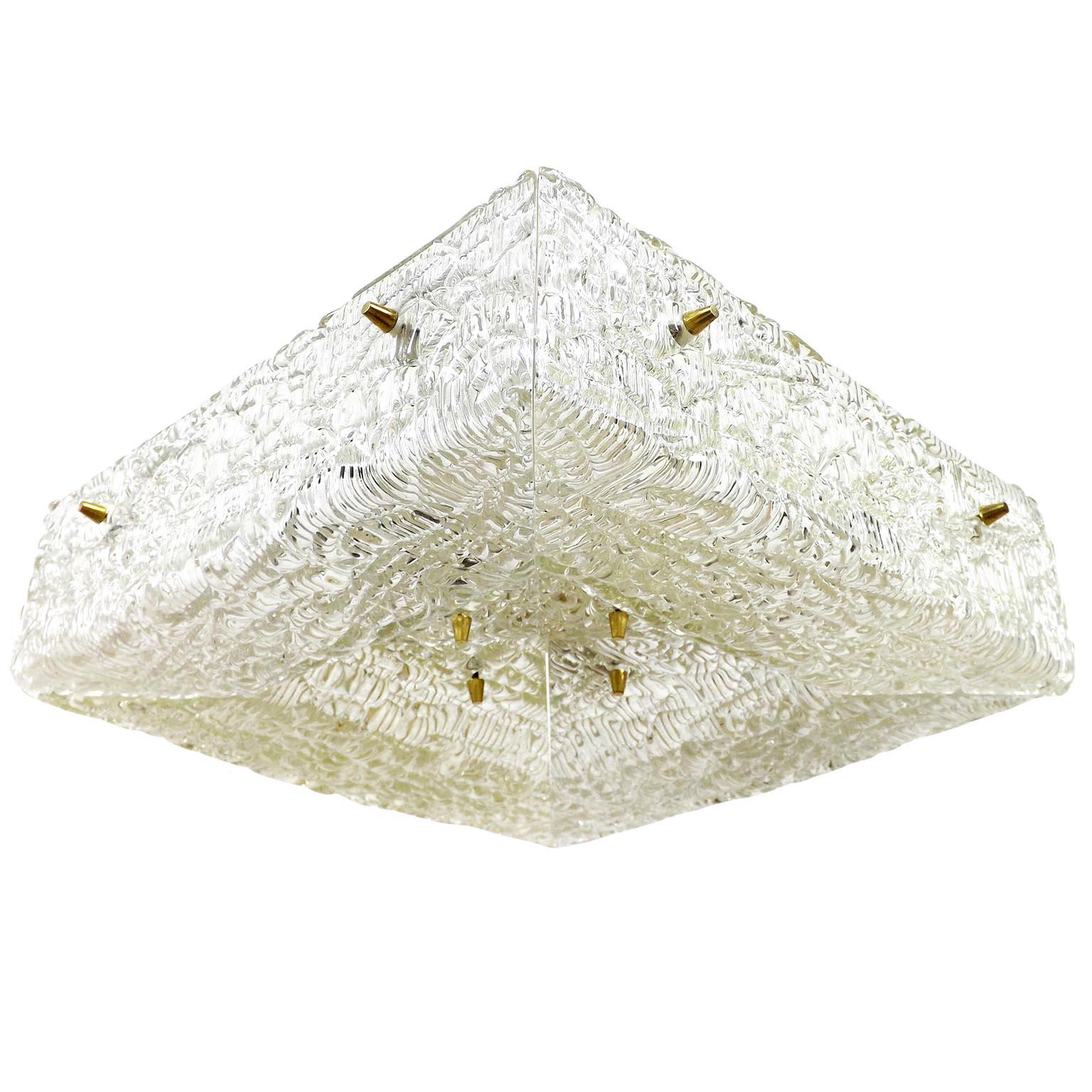 One of four textured glass and brass flush mount lights by J.T. Kalmar, Austria, manufactured in midcentury, circa 1960 (late 1950s or early 1960s).
A square pressed glass with a watery structure is divided into four parts which are mounted with