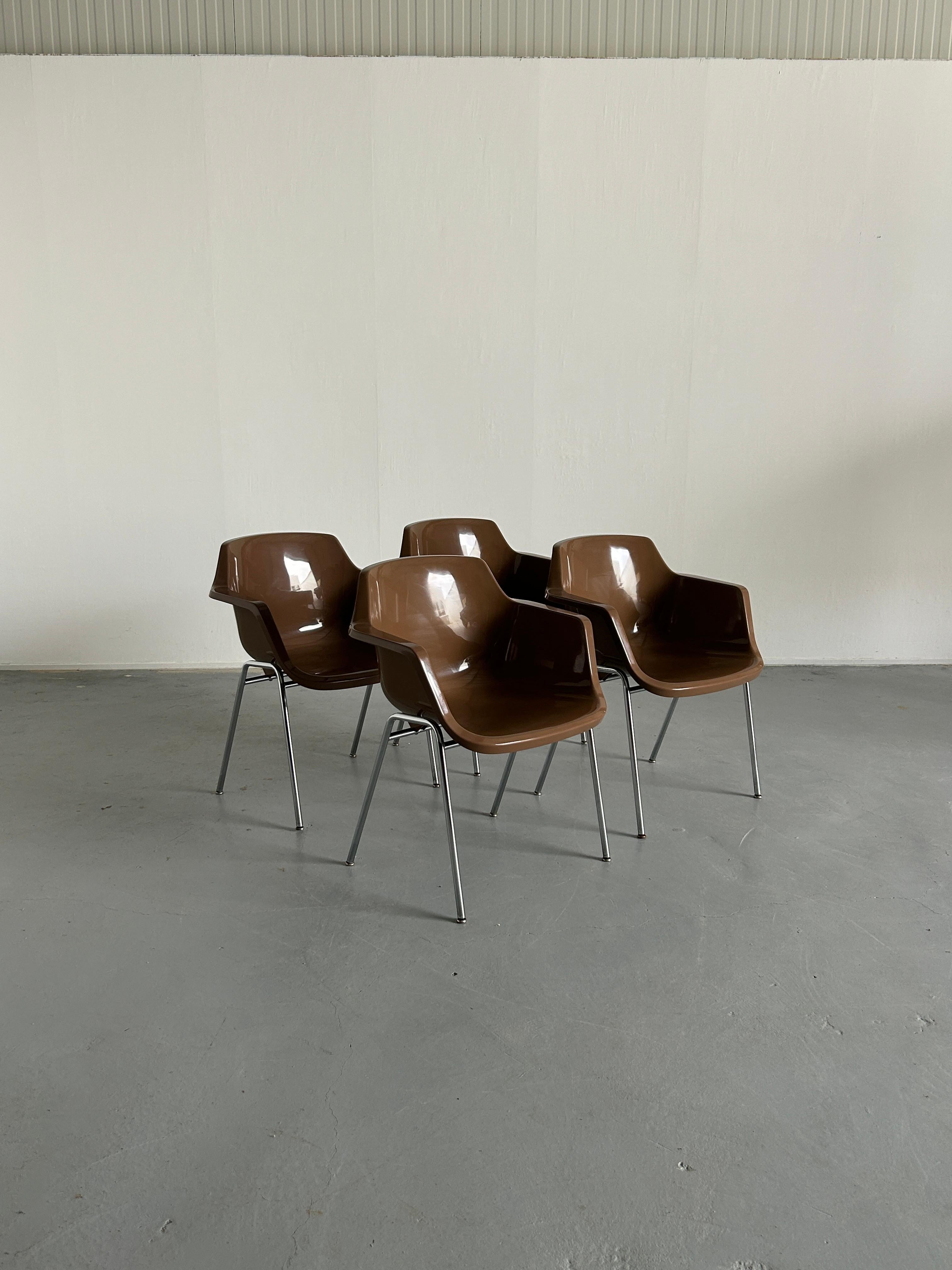 Four high-quality production Mid-century Modern dining chairs made from a chromed metal base and shell high-gloss brown plastic seat.
Produced in March, 1973 (engraved).

In good vintage condition with minimal expected signs of age, as indicated on
