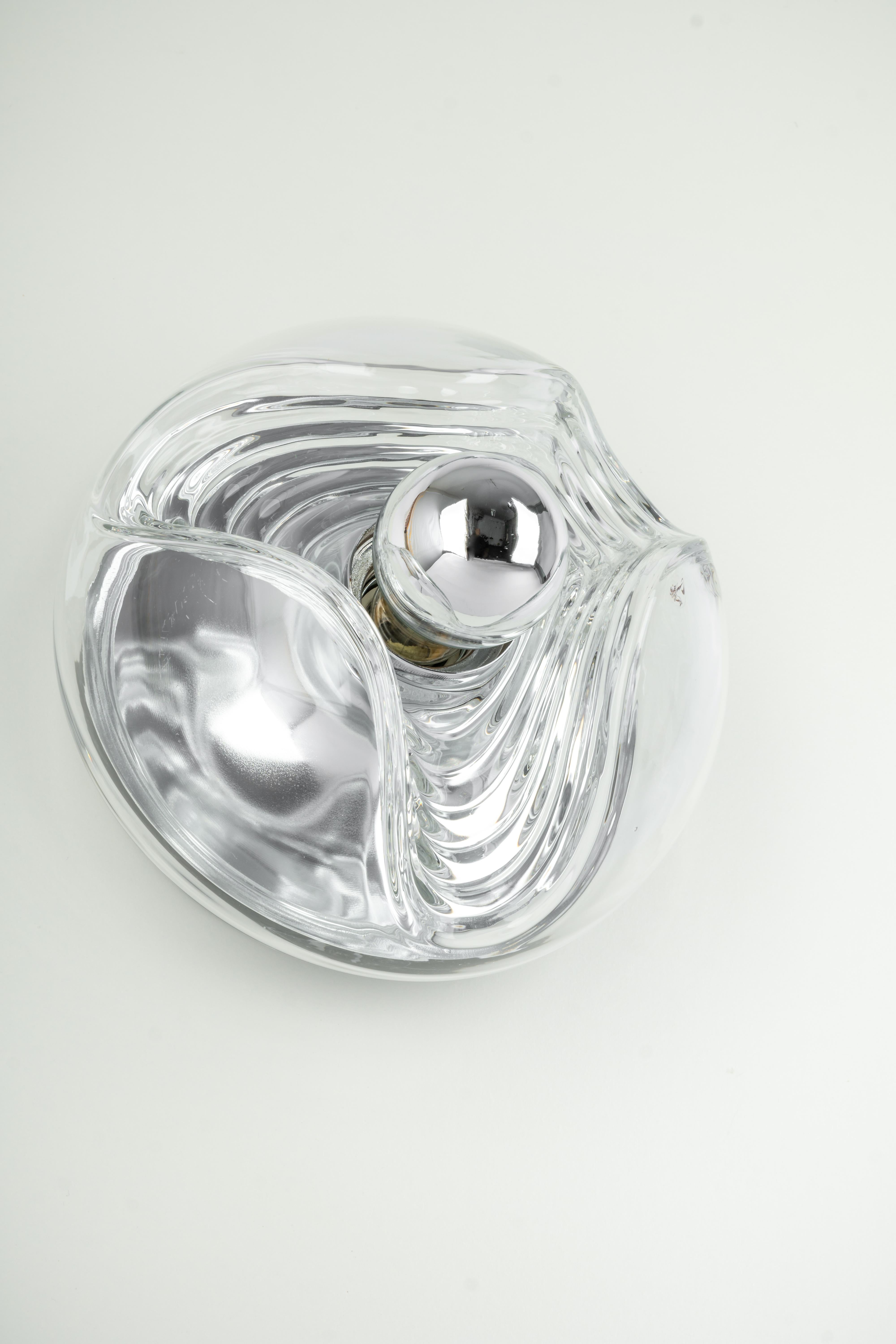 Eine besondere runde biomorphe Wandleuchte aus klarem Kristallglas, entworfen von Koch & Lowy für Peill & Putzler, hergestellt in Deutschland, ca. 1970er Jahre.

Fassungen: Eine x E27 Standard-Glühbirne. (100 W max).
Glühbirnen sind nicht enthalten.