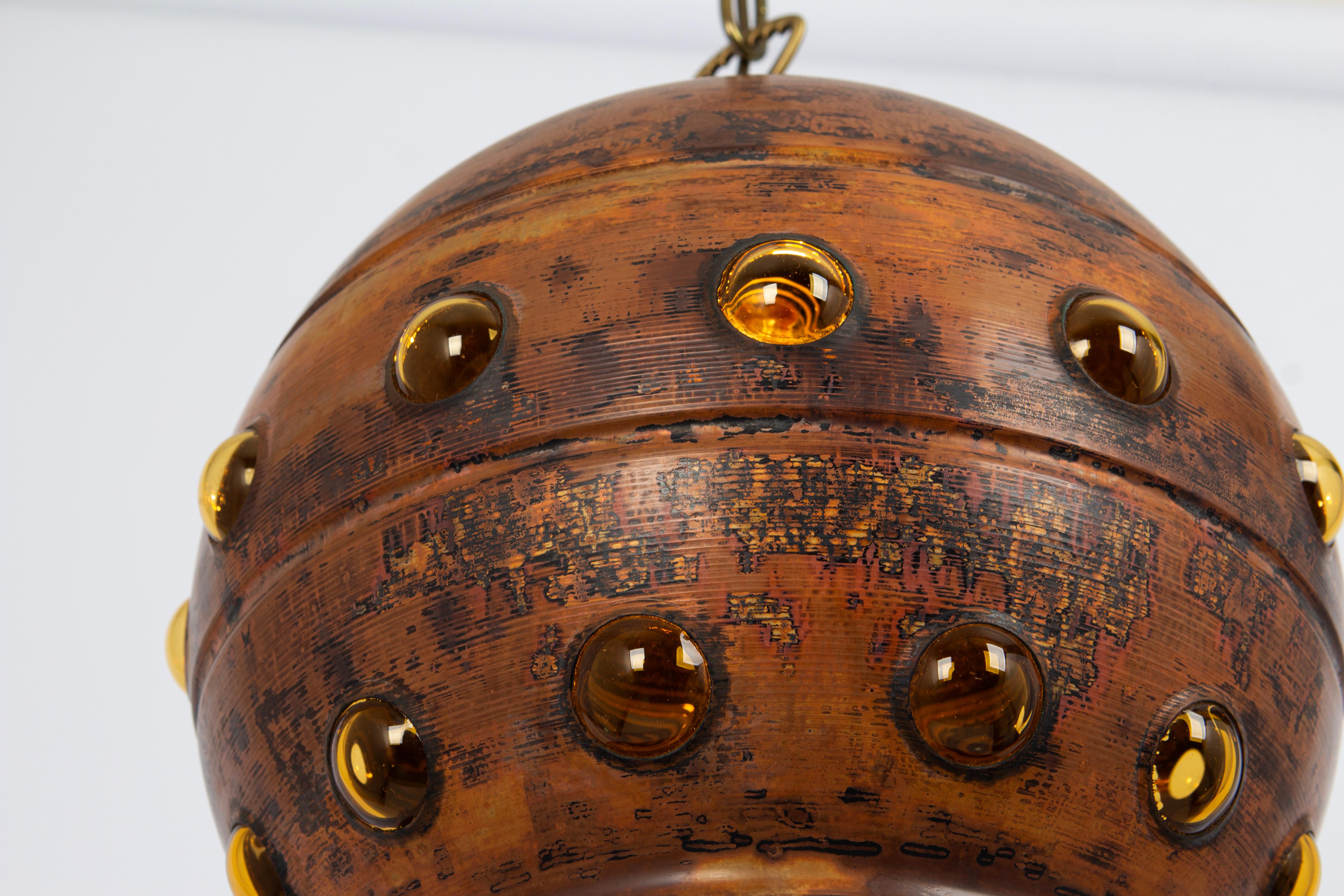 Questa lampada è unica nella sua esecuzione e nella sua patina.
Il vetro giallo dorato viene soffiato in una sfera di rame, creando delle bolle. 

Nello stile della stilista Nanny Still realizzata negli anni '60.
Buone condizioni originali.

Prese