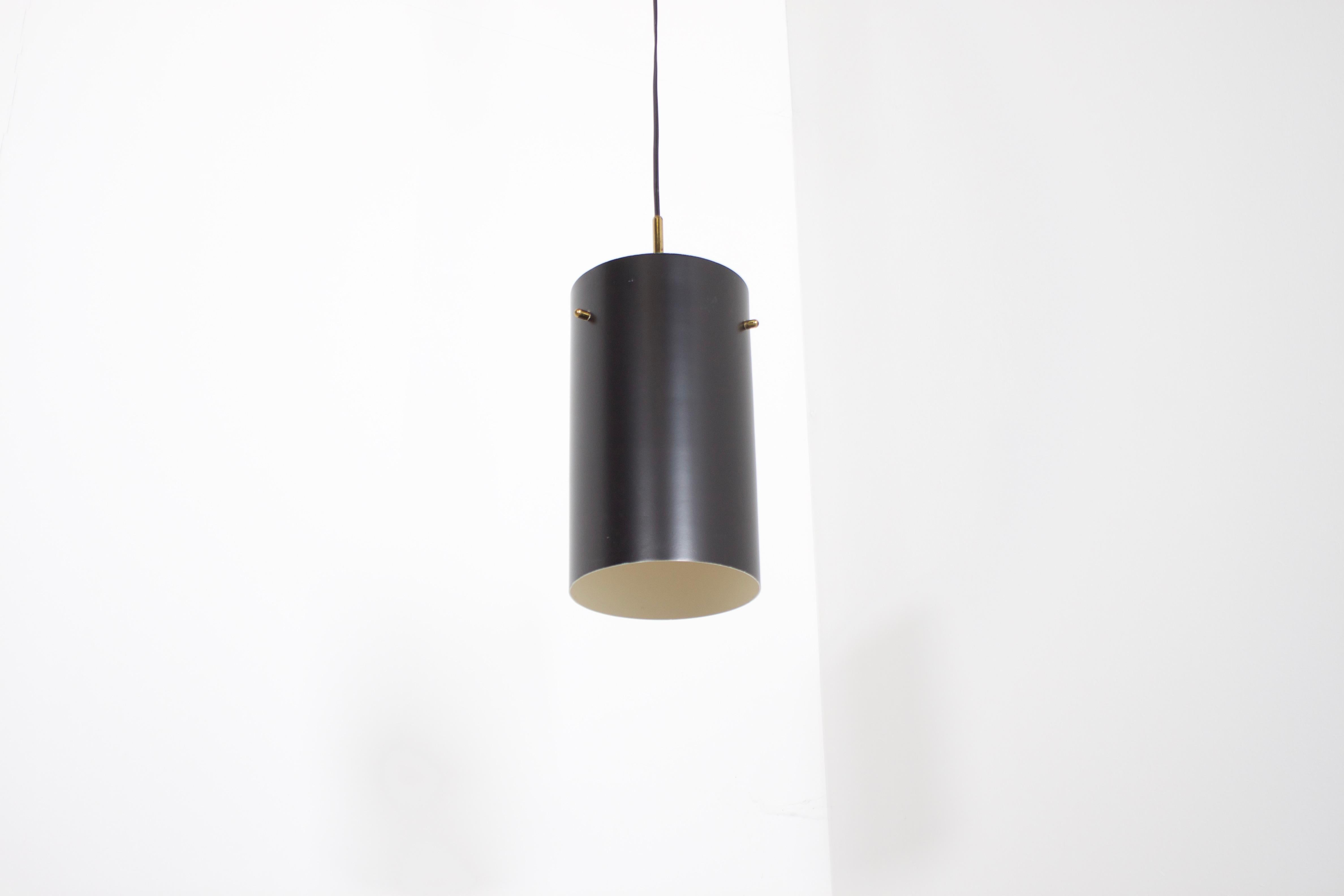 Minimalist Italian pendants in very good condition.

6 pieces available. 

Manufactured by Stilnovo in the 1950s. 

Executed in brass and black lacquered metal.

The cylindrical metal shade hangs on a frame with solid brass rods.

Original