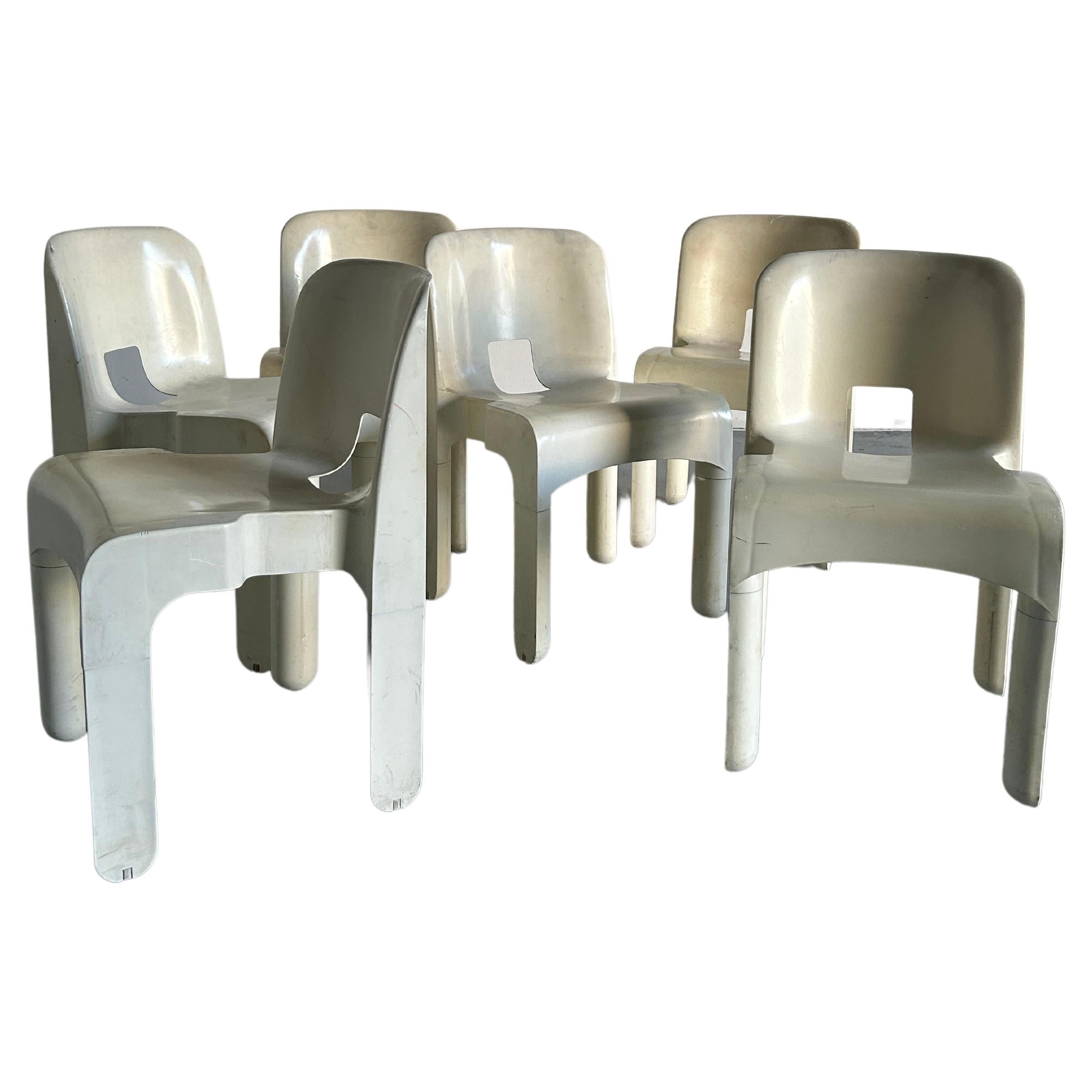 Iconic Italian Mid-century white plastic chairs model 4867 by Joe Colombo for Kartell. 
The model 4867 is also known as 'Universale' chair. The rectangular seat has two flaps on the outside. The slightly curved backrest is rectangular with rounded