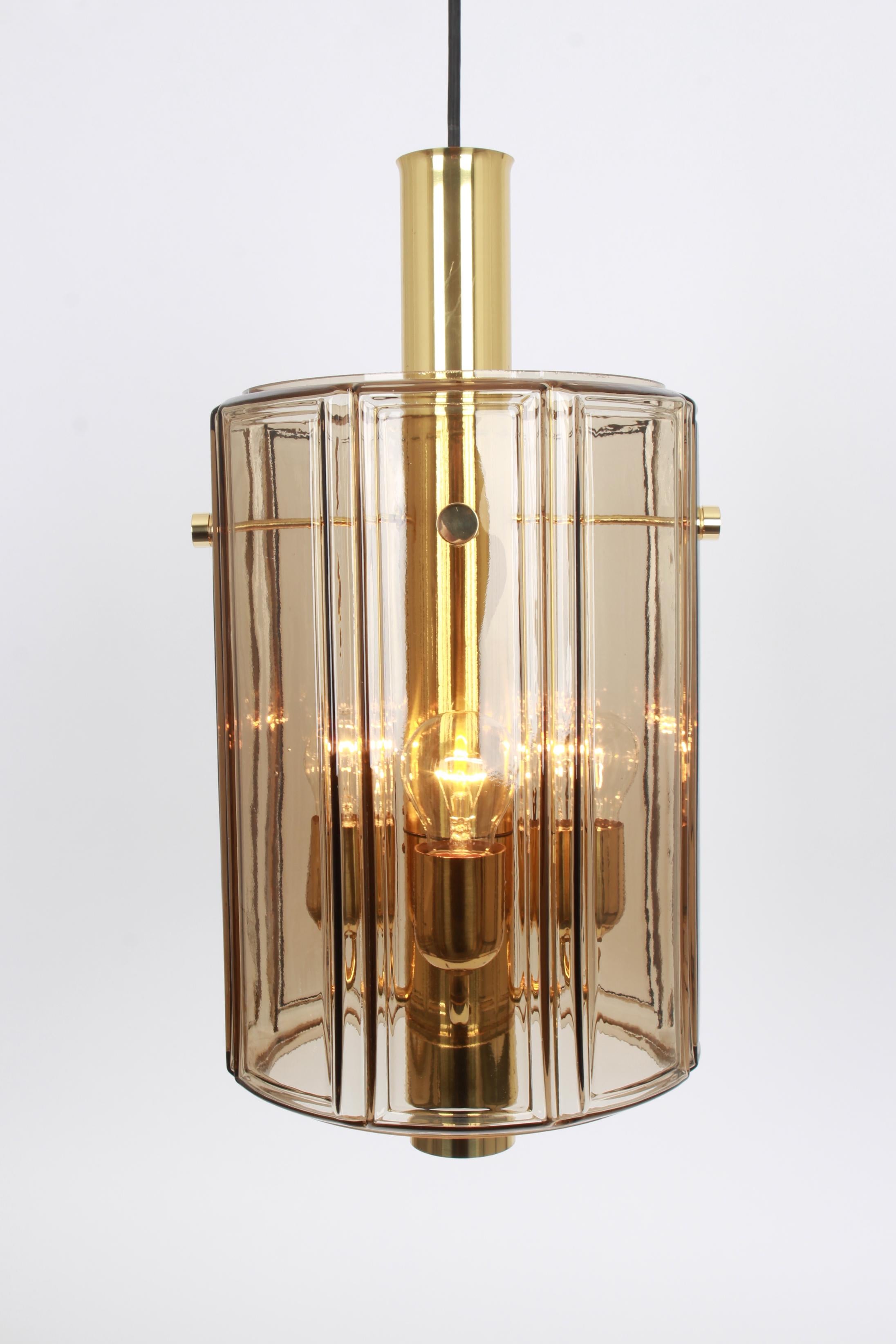 Brass pendant fixture with cylindrical glass shade design by Limburg, Germany, 1960s

Heavy quality and in very good condition. Cleaned, well-wired, and ready to use. The fixture requires 4 x E27 Standard bulbs with 100W max each and function on a