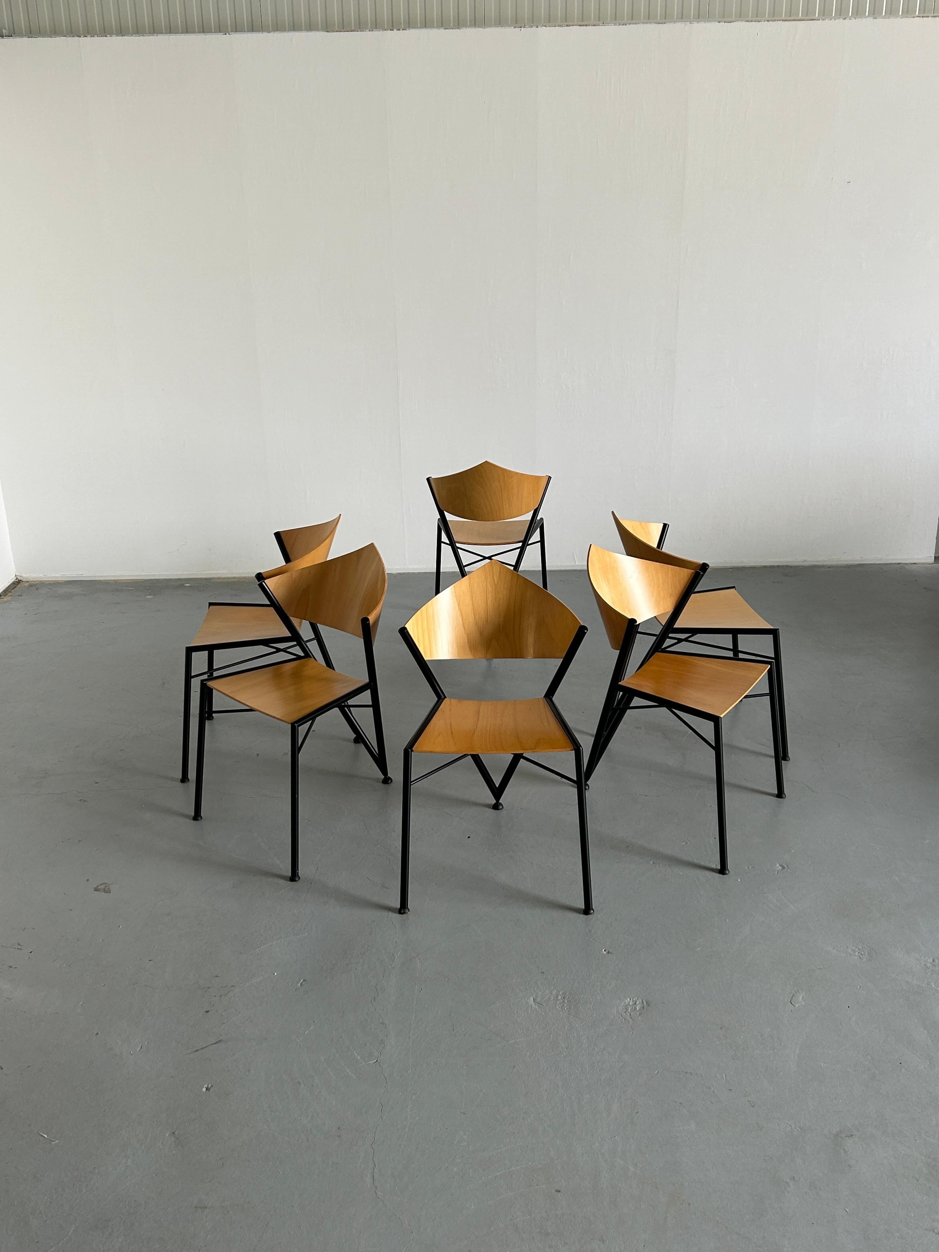 Six metal frame and plywood postmodern chairs designed and produced in the 1980s. Triangle shapes dominating the design and resulting in a three-legged structure.
The design of the chairs shows strong influences from the Milanese Memphis