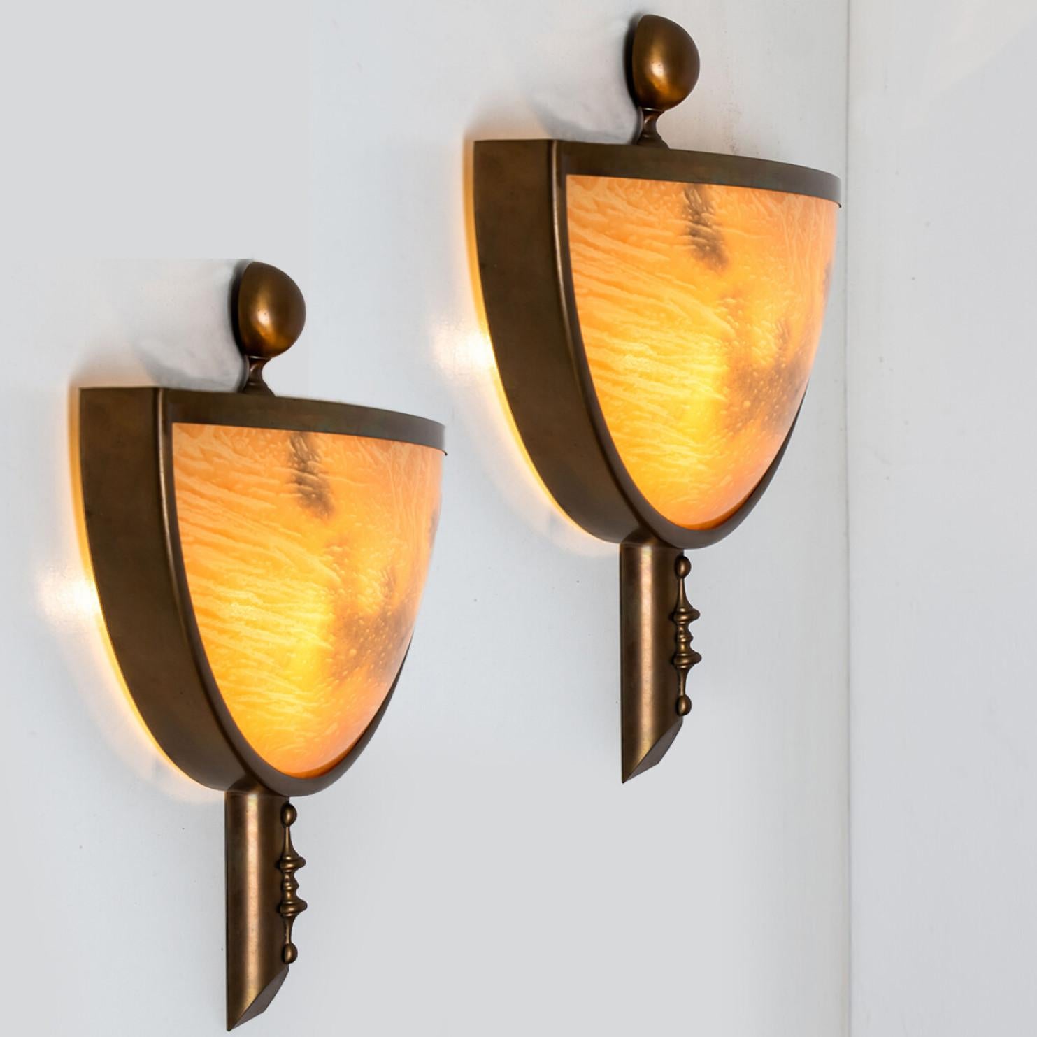 Art deco style brass and marbled glass wall lights. Light orange and grey, dark brassed material. Manufactured in Italy around 1970.
With their clean modernist lines and beautiful attention to detail, these sconces would be a winning addition to any