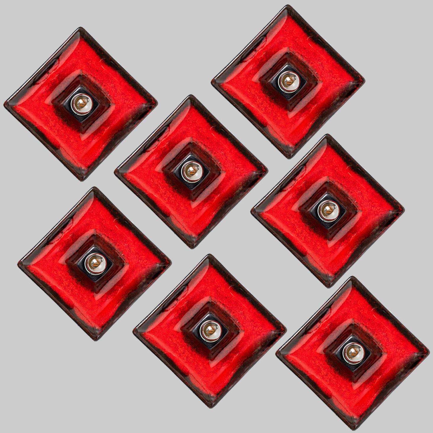 this spectacular graphical red dark brown  ceramic wall lights manufactured in Germany in the 1970s.

The glaze is in a red and dark brown color.

We used  silver light bulbs (see images), but gold or white light bulbs are also very stylish (see