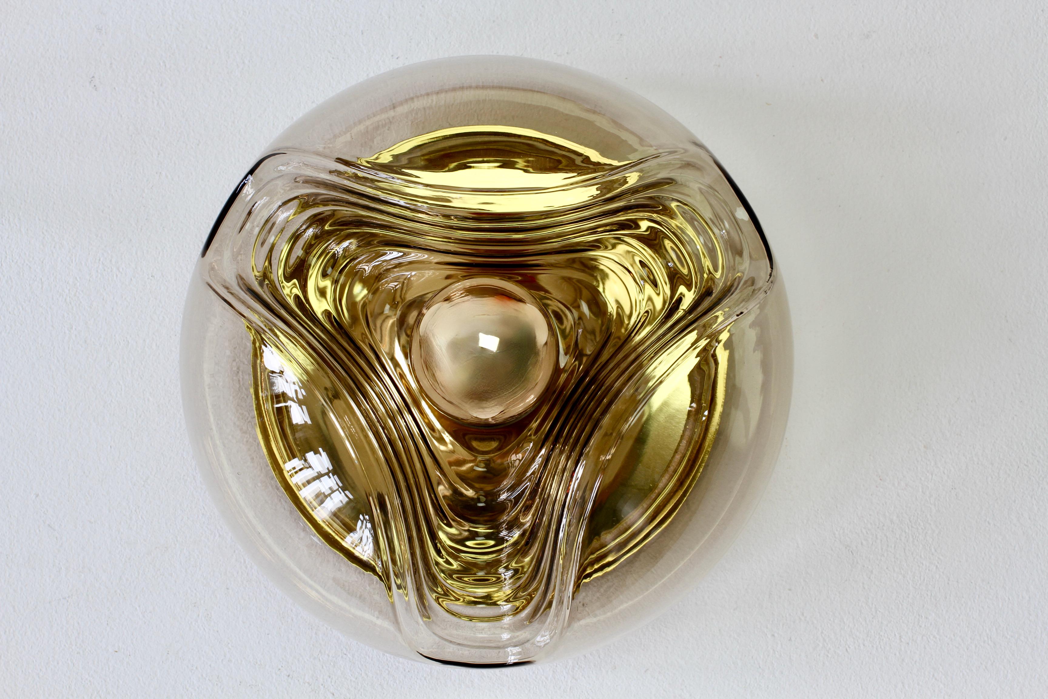 One of a large set of eight mid-century flush mount ceiling or wall lights / sconces by Peill & Putzler in the 1970s. This is an absolutely Classic piece of design, featuring a smoked coloured (colored) glass globe shade with a waved/ribbed molded