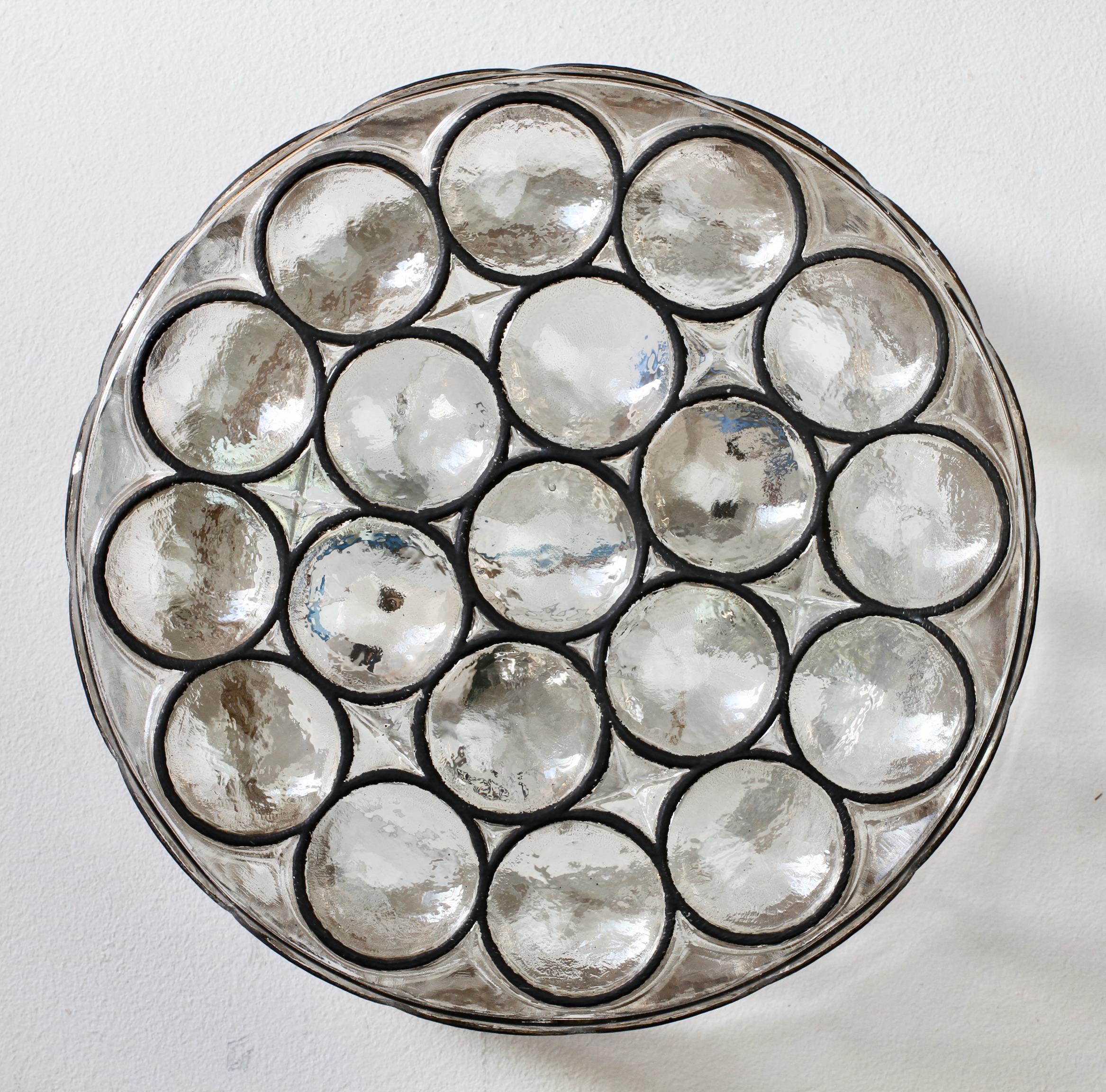 One of a pair of Mid-Century Modern vintage Glashütte Limburg, large double socketed circular iron and glass flush mount lights / sconces made in Germany, circa 1965. Featuring thick, heavy blown glass with concave round 