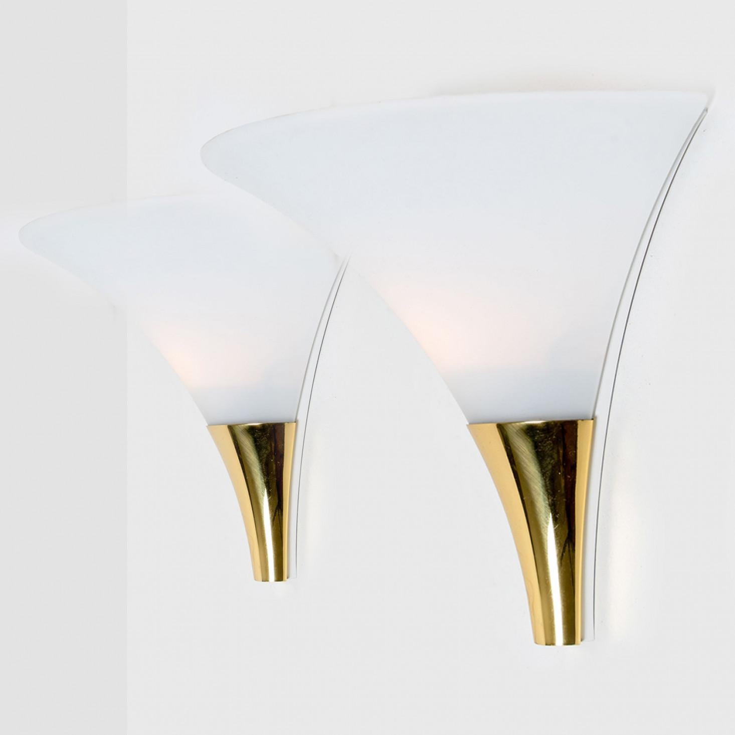 1 of the 16 funnel shaped wall lamps by Glashütte Limburg made in Germany, Europe in the 1970s.
They have a beautiful cone shape and are made of beautiful white, opaque glass and solid brass.
This wall light gives a warm light that suits any