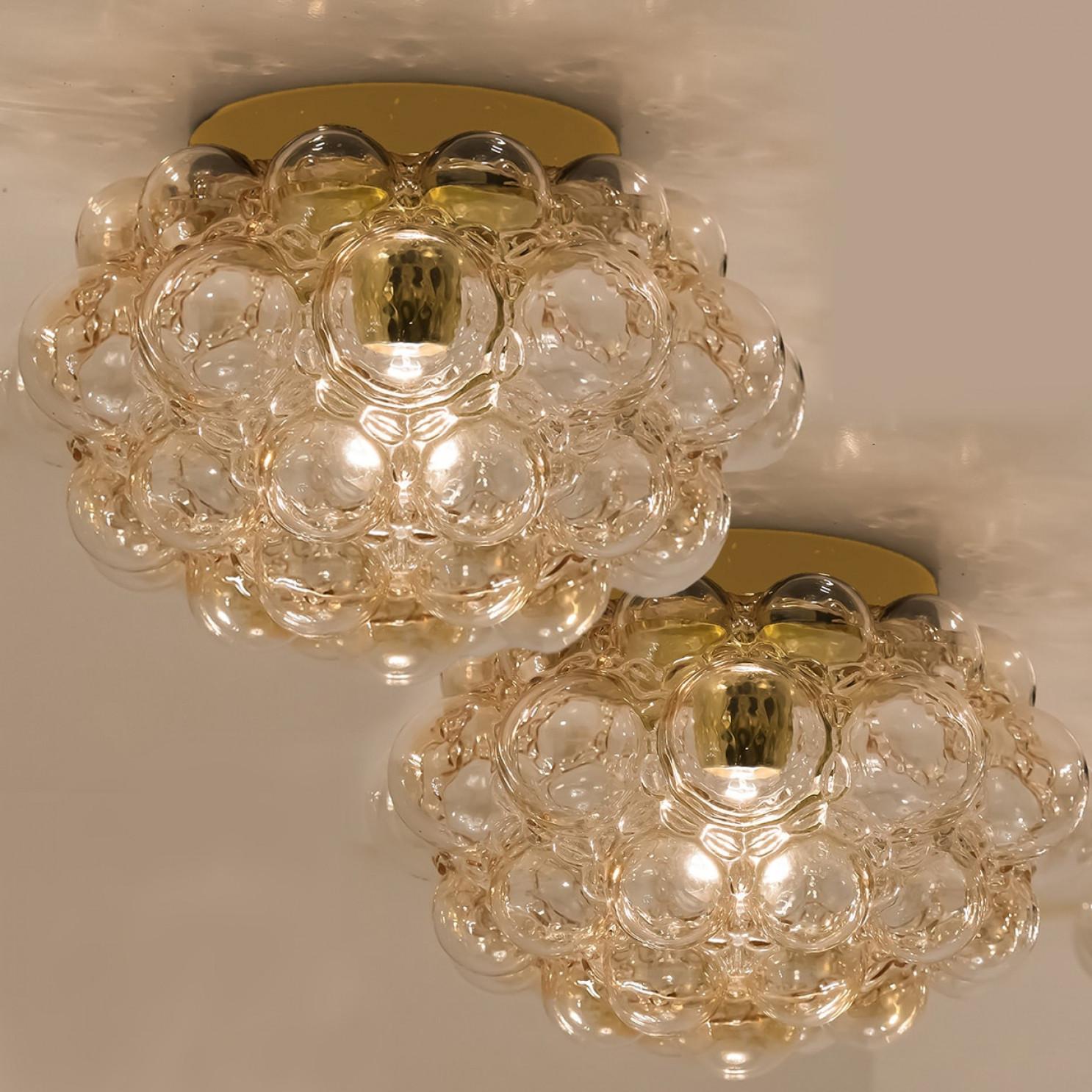 1 dei 2 bellissimi apparecchi di illuminazione in vetro a bolle d'aria disegnati da Helena Tynell per Glashütte Limburg. Design classico, il vetro soffiato a mano dona una meravigliosa luce calda. Si illumina magnificamente sulla parete e sul