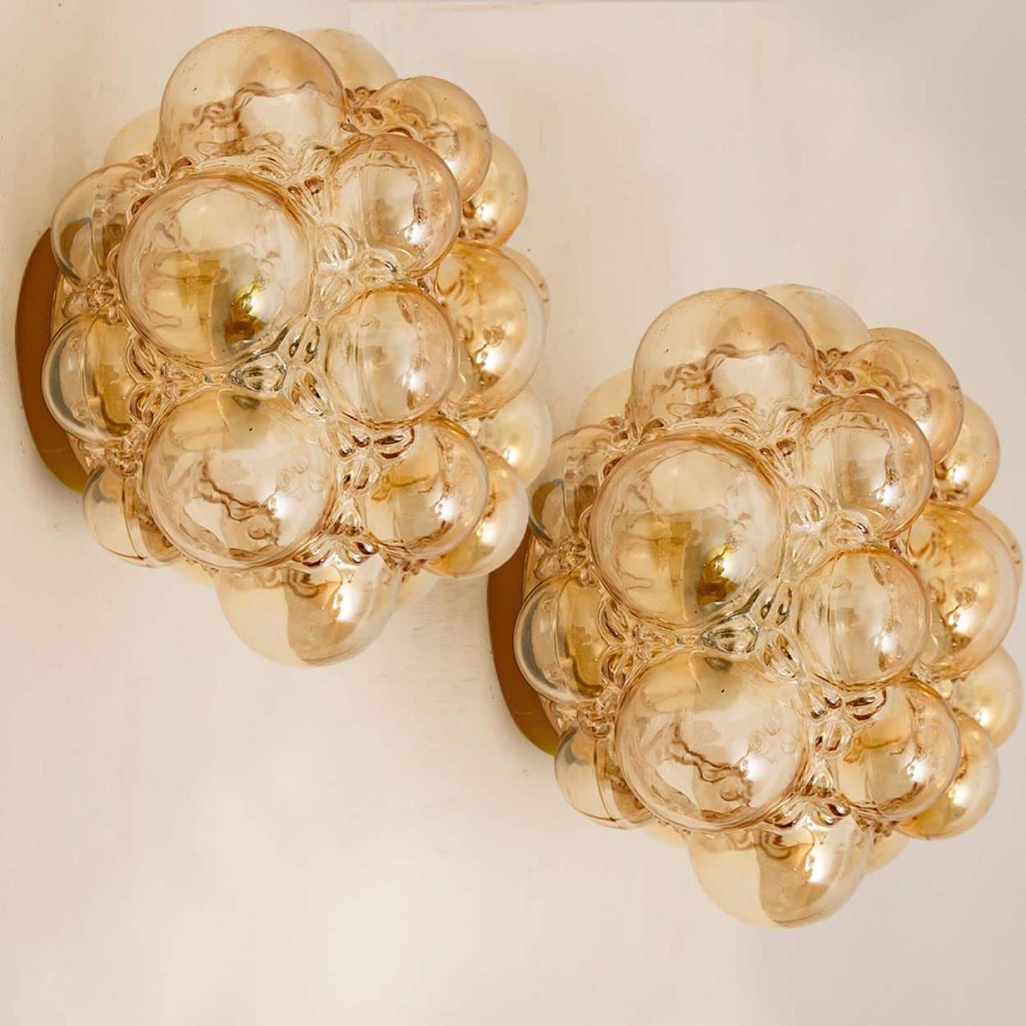 1 dei 2 bellissimi apparecchi di illuminazione in vetro a bolle d'aria disegnati da Helena Tynell per Glashütte Limburg. Design classico, il vetro soffiato a mano dona una meravigliosa luce calda. Si illumina magnificamente sulla parete e sul