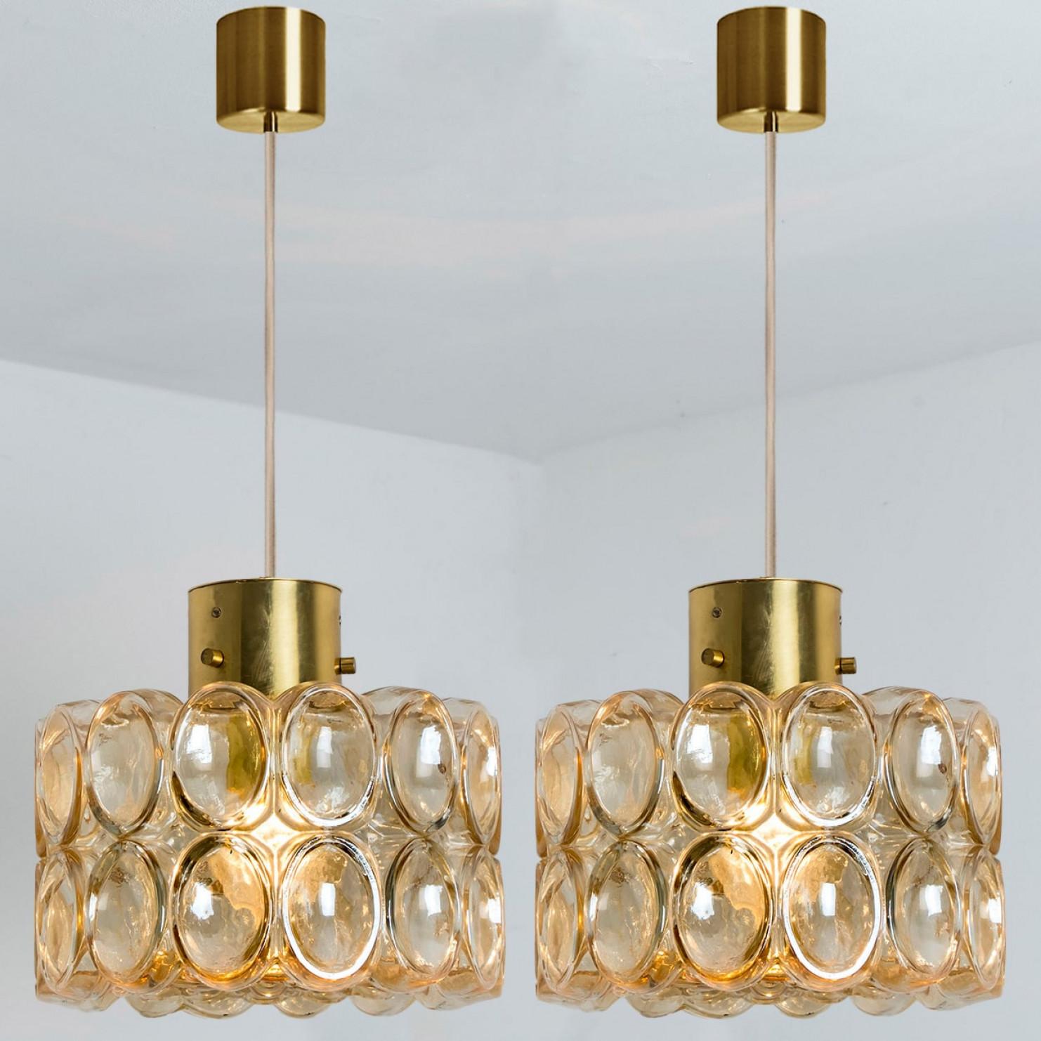 Varias preciosas lámparas colgantes de cristal burbuja diseñadas por Helena Tynell para Glashütte Limburg, 1960. Un diseño clásico con detalles cromados, el vidrio ámbar soplado a mano le da un brillo maravilloso.

Helena Tynell es diseñadora de