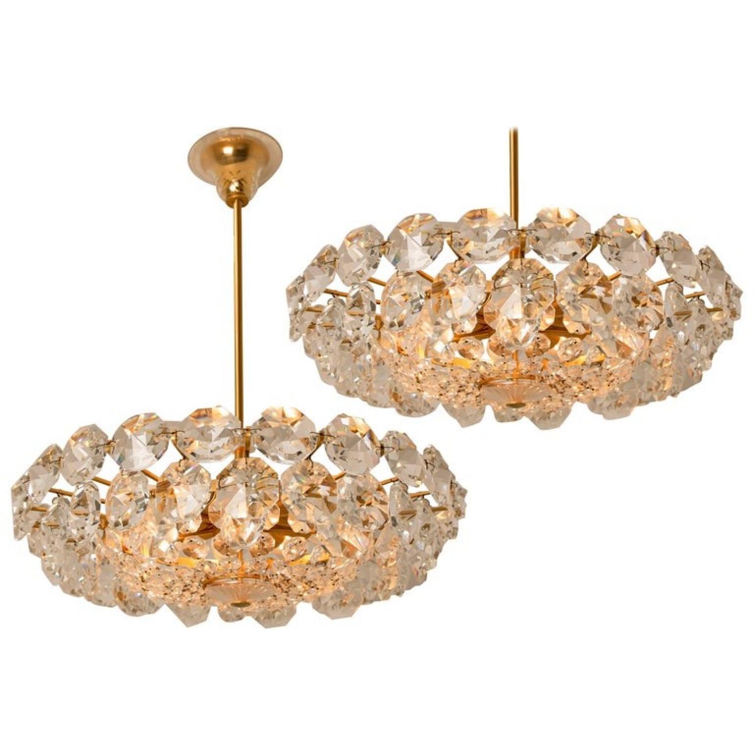 A stunning modern chandelier by Bakalowits. Handmade and high-quality piece. Featuring large-scale octagonal faceted crystals on a 22-karat gold washed brass frame and chain. The fixture is made of gilt brass and has three rings with lots of faceted