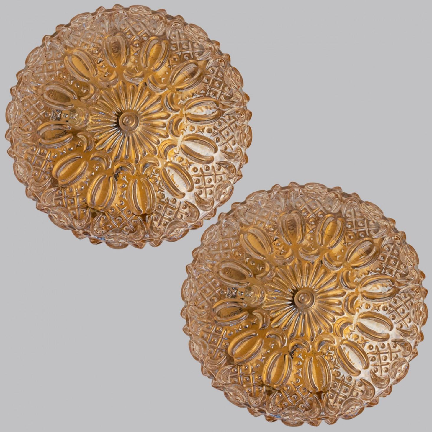 1 of the 2 Amber glass flush mounts in the style of Helena Tynell around 1960-1970 in Europe, Germany. The rich textured glass gives a wonderful glow. The round glass is mounted on a brass colored metal back plate.

Can be used as a wall light or