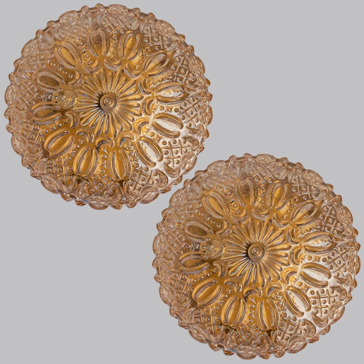 1 des 2 montures encastrées en verre ambré dans le style d'Helena Tynell vers 1960-1970 en Europe, Allemagne. Le verre richement texturé donne un éclat merveilleux. Le verre rond est monté sur une plaque arrière en métal de couleur laiton.

Peut