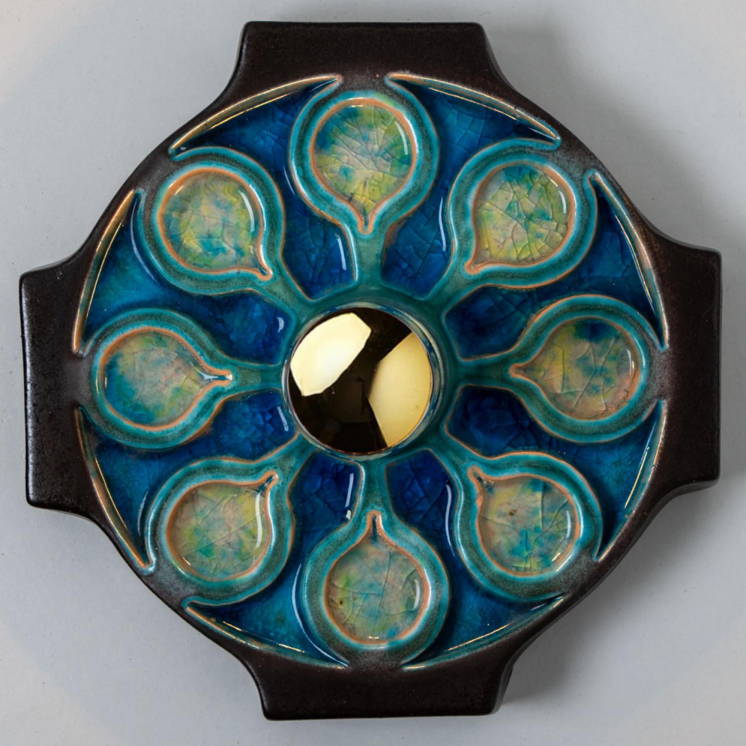 Keramik-Wandleuchte oder Wandleuchter aus der Mitte des Jahrhunderts, hergestellt in Deutschland um 1960.
Die Leuchte ist aus Keramik gefertigt und in blauen Farbtönen dekoriert und glasiert.

Unterschiedliche Effekte können durch den Einsatz
