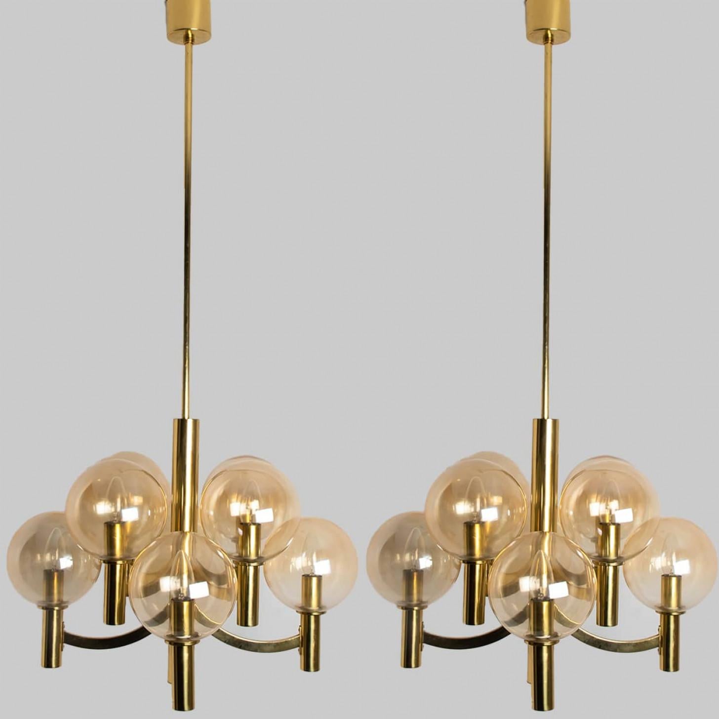 Splendido lampadario con ciotole in vetro trasparente e base e accessori in ottone. Prodotto negli anni '70 nello stile di Hans-Agne Jakobsson. Illumina meravigliosamente.

Dimensioni:
Altezza: 110 cm (43,30