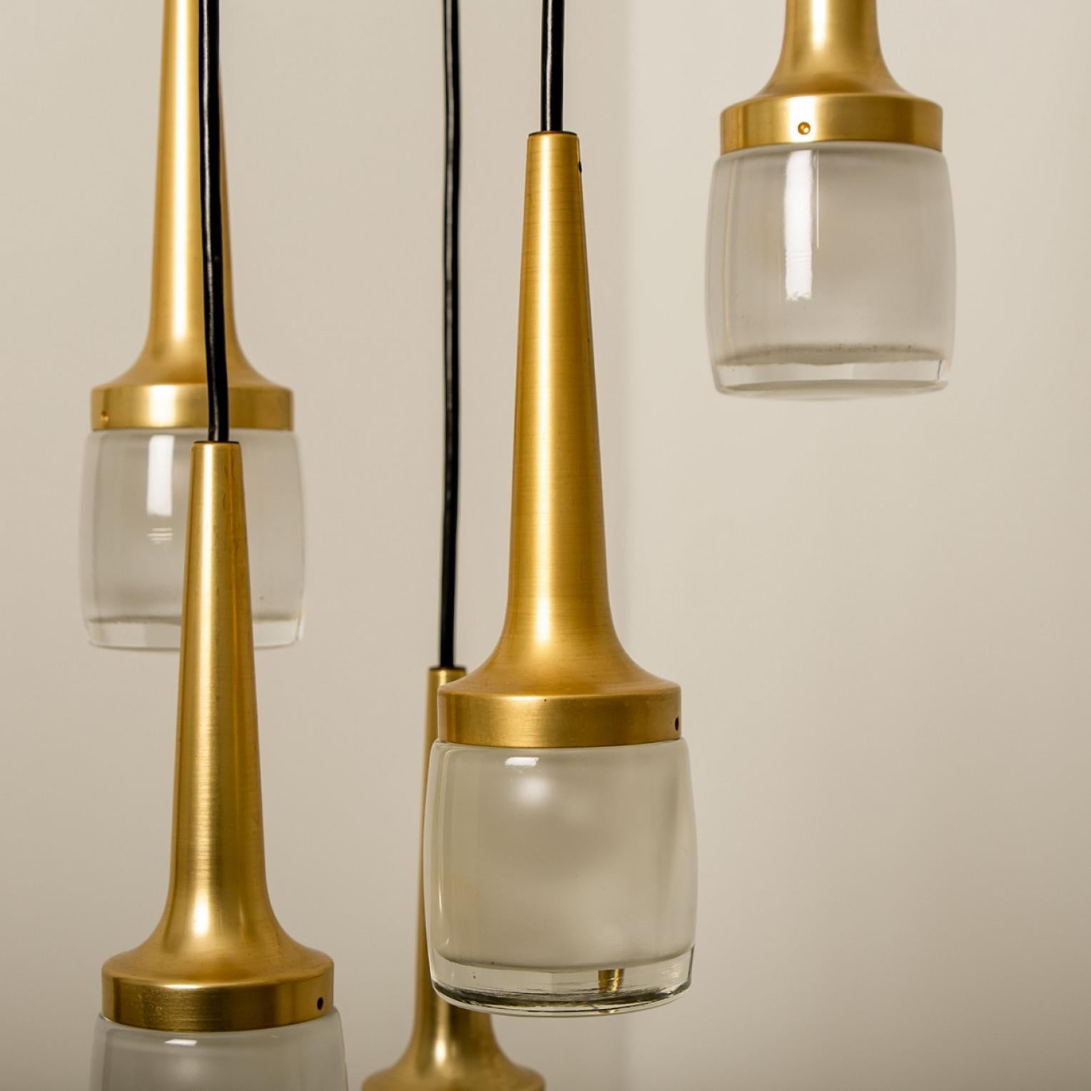 1 of the 2 elegant cascade with 6 light fixtures was manufactured by Staff Leuchten in Germany. The light is executed in brassed aluminium and thick off white opaline molded glass etched on the inside. Playful to arrange by playing with the length