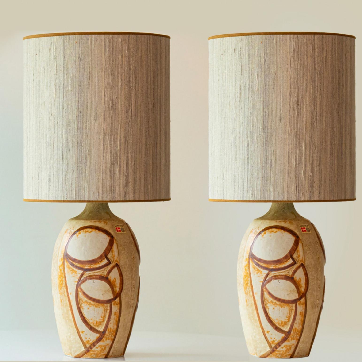 Beautiful set of two ceramic table lamps by, Noomi Backhausen for Soholm, Denmark 1960s.

The warm beige tones of the base and the beige lampshade (with lovely trimming) complement each other very well and illuminate beautifully. The silk shade has