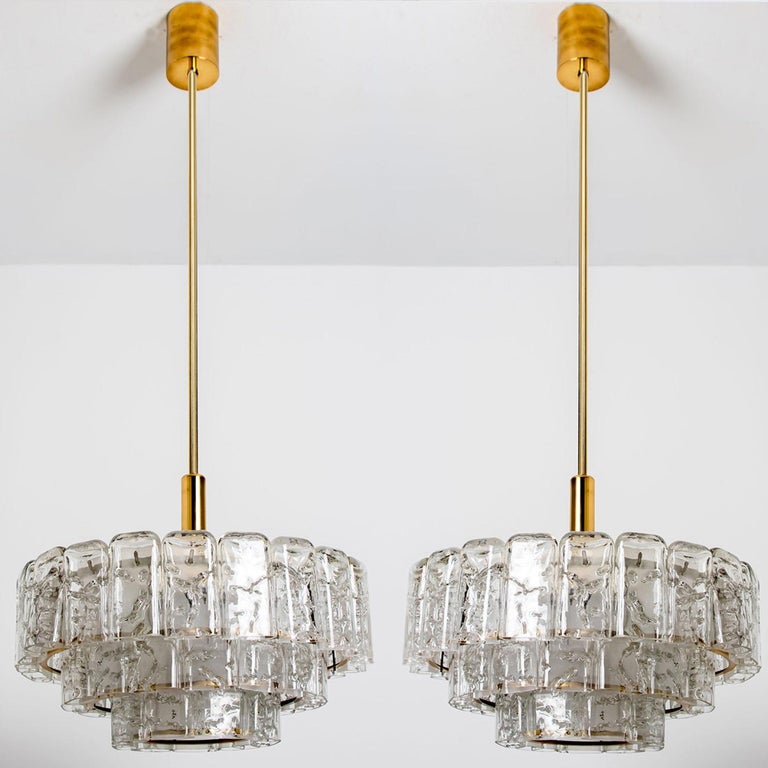Fantastic three-tier midcentury chandelier by Doria Leuchten Germany. Manufactured around 1960.
Three rings of Murano glass cylinders suspended from a fixture with brass details. Heavy quality and in very good condition. 

Cleaned, well-wired and