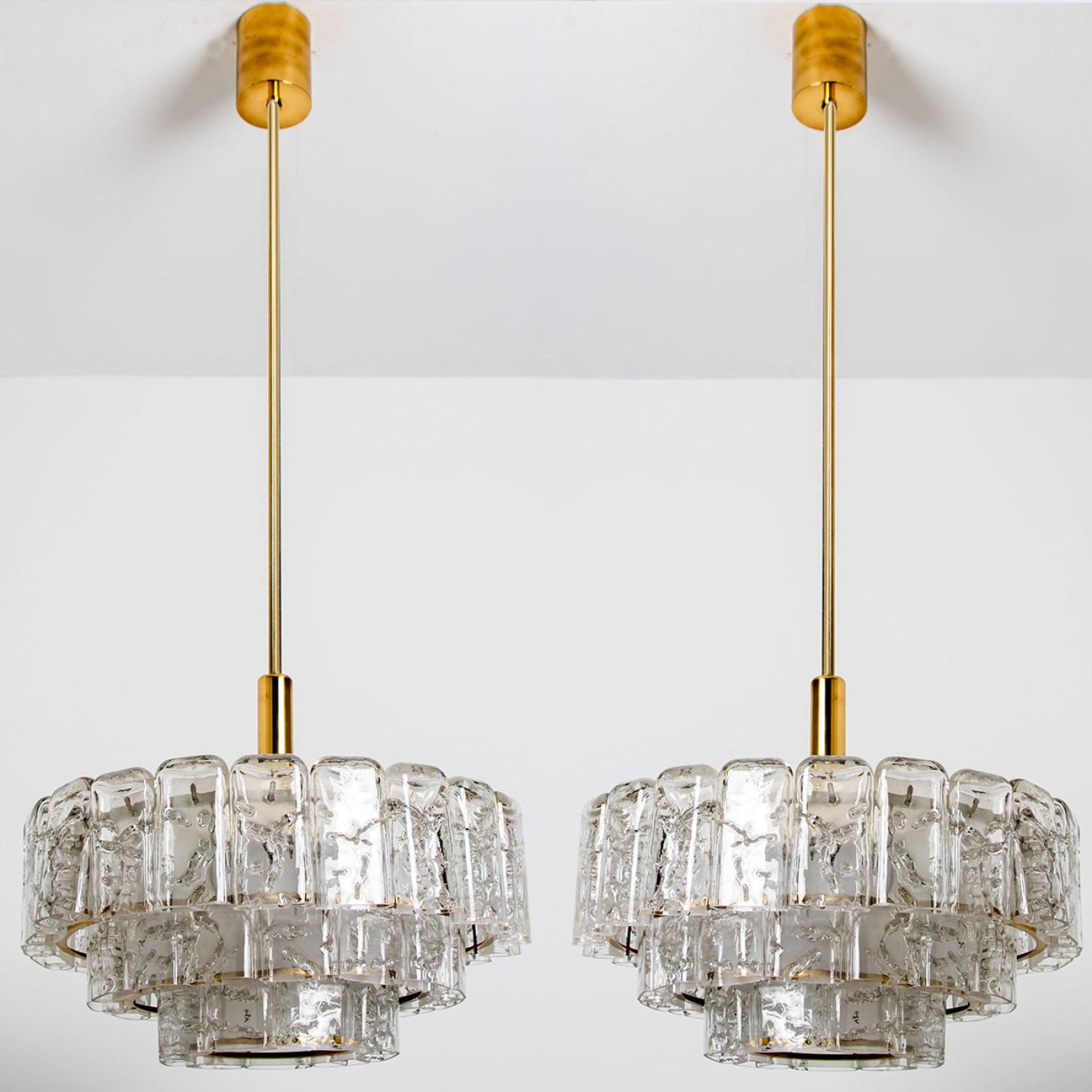 Fantastic three-tier midcentury chandelier by Doria Leuchten Germany. Manufactured around 1960.
Three rings of Murano glass cylinders suspended from a fixture with brass details. Heavy quality and in very good condition. 

Cleaned, well-wired and