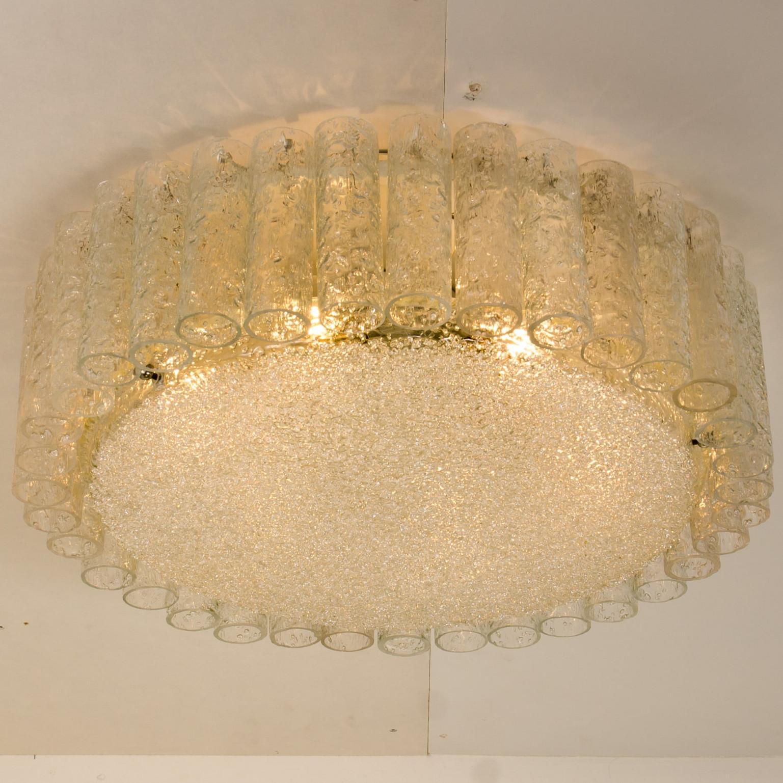 Zwei große, bündig montierte Doria-Kronleuchter mit organischen Glasröhren, die einen zentralen Glasdiffusor umgeben, montiert mit minimalen, sichtbaren Beschlägen für ein klares und elegantes Aussehen.

Die stilvolle Eleganz dieser Lampe passt zu