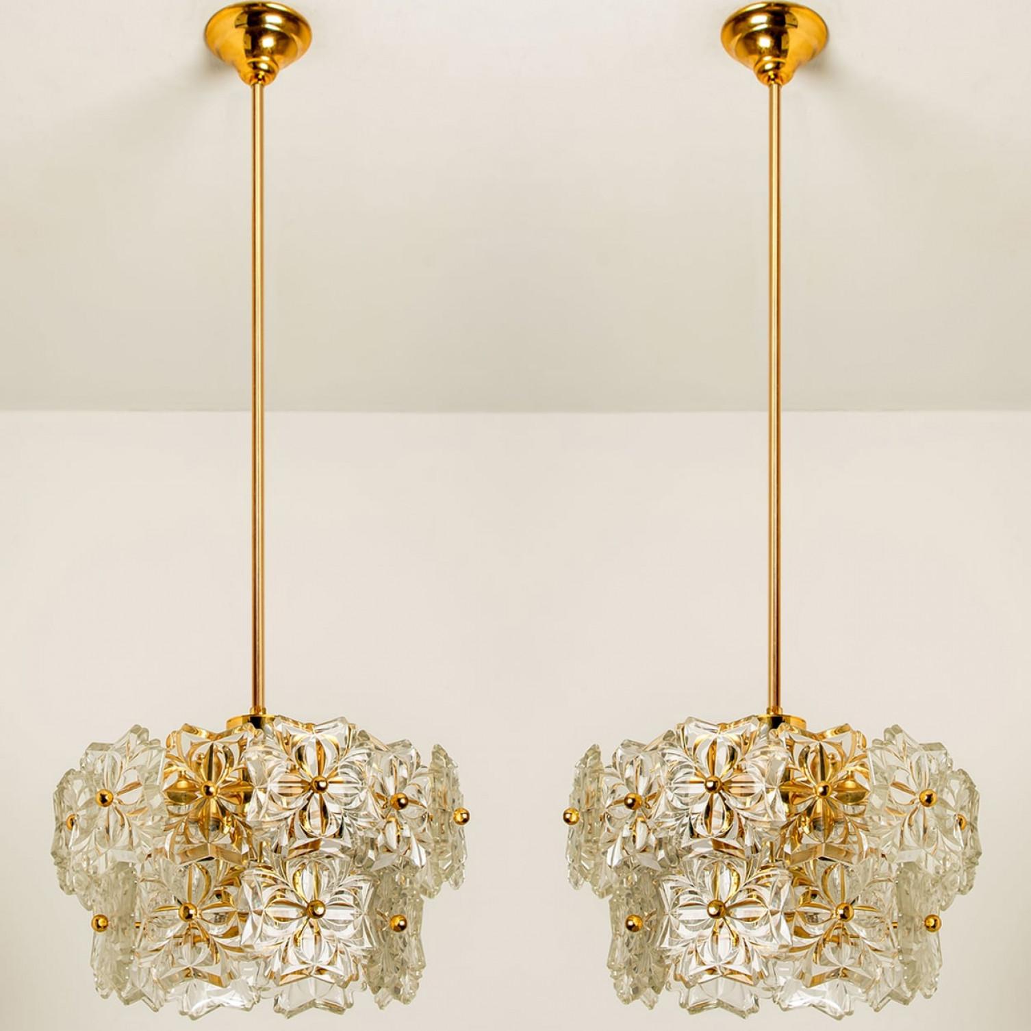 One of the two sculptural chandeliers has the design of a bouquet of textured glass flowers and are from the historical lighting company Hillebrand, manufactured in mid century, circa 1970 (late 1960s or early 1970s).

The fixture has several flower