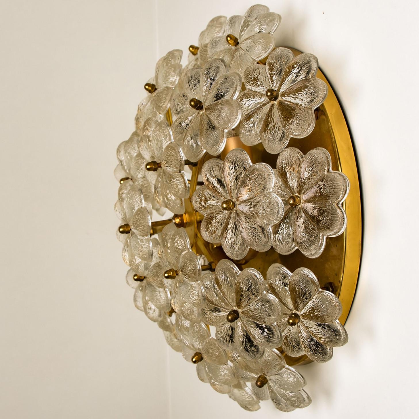 This sculptural wall light has the design of a bouquet of textured glass flowers and are from the historical lighting company Ernst Palme.

Each clear glass flower shade has textured petals and is securely screwed in place to the frame with a gilt