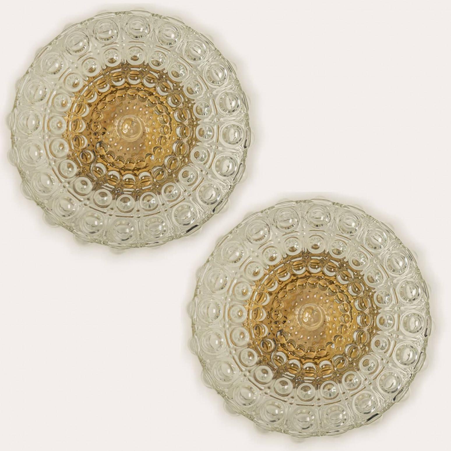 Una delle due applique in vetro trasparente a bolle progettate nello stile di Helena Tynell intorno al 1960-1970 in Europa, Germania. Il vetro con bolle dalla consistenza ricca dona una luce meravigliosa. Il vetro rotondo è montato su una piastra