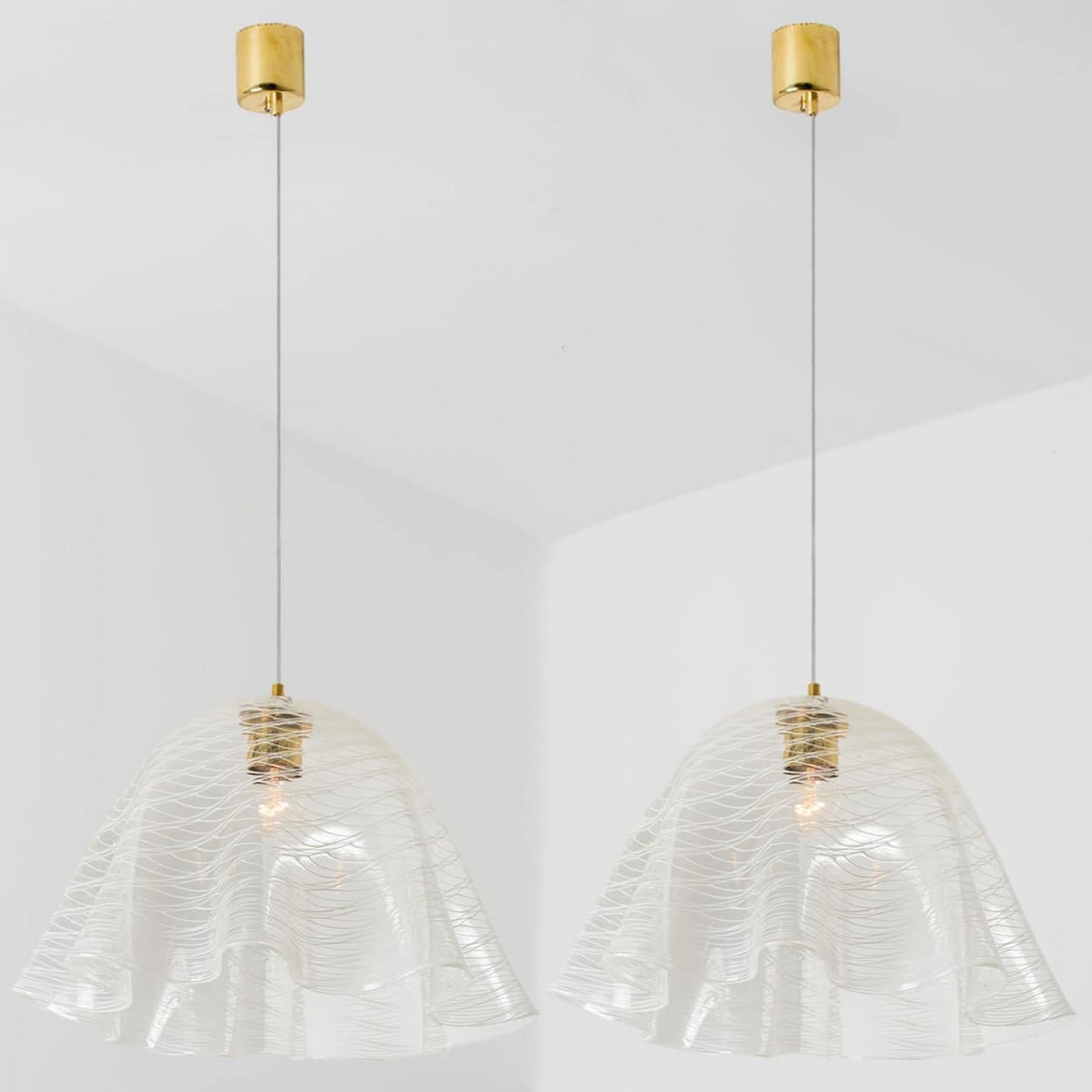 L'une des deux belles suspensions en verre de haute qualité du milieu du siècle avec de belles lignes. Conçu et réalisé par Kalmar Vienna dans les années 1970. Fabriqué en verre clair et blanc soufflé à la bouche.

Nettoyé et bien câblé, en parfait
