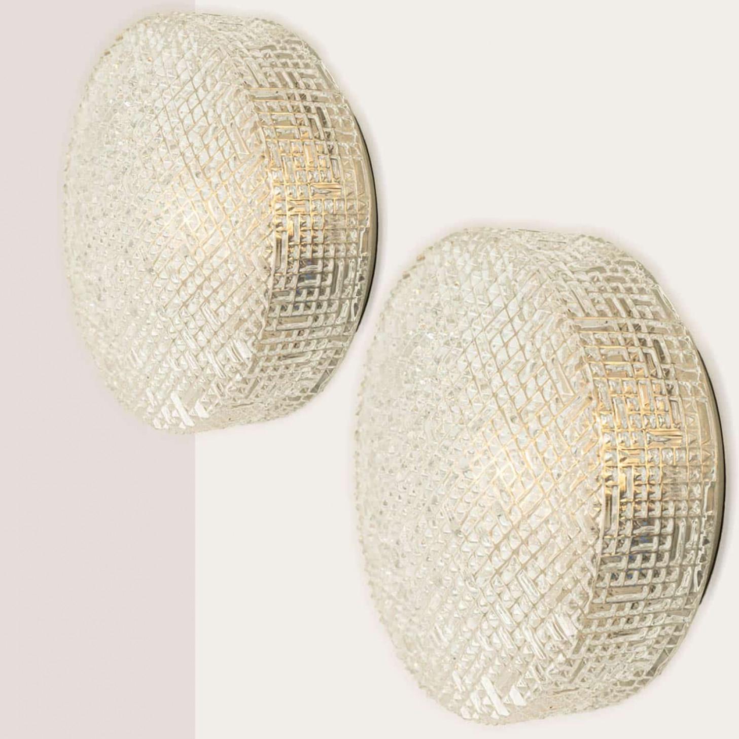Una delle due applique in vetro trasparente a bolle progettate nello stile di Helena Tynell intorno al 1960-1970 in Europa, Germania. Il vetro ricco di texture con i piccoli cubi sopra, dona una luce meravigliosa. Il vetro rotondo è montato su una