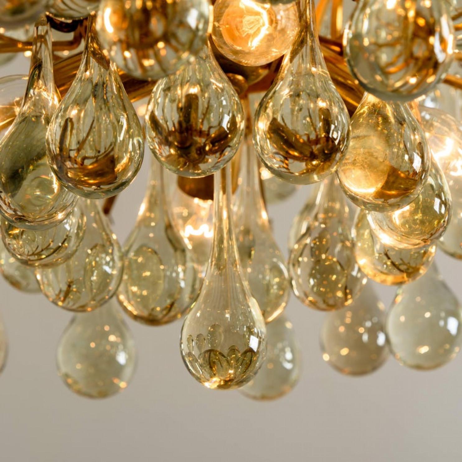 This amazing elegant chandelier was made in the 1970s by the iconic firm Ernst Palme in the 1970s. The piece is gold-plated and the 97 wonderful crystal prisms are in a tear-drop form. It is one of the largest chandelier in this model series.