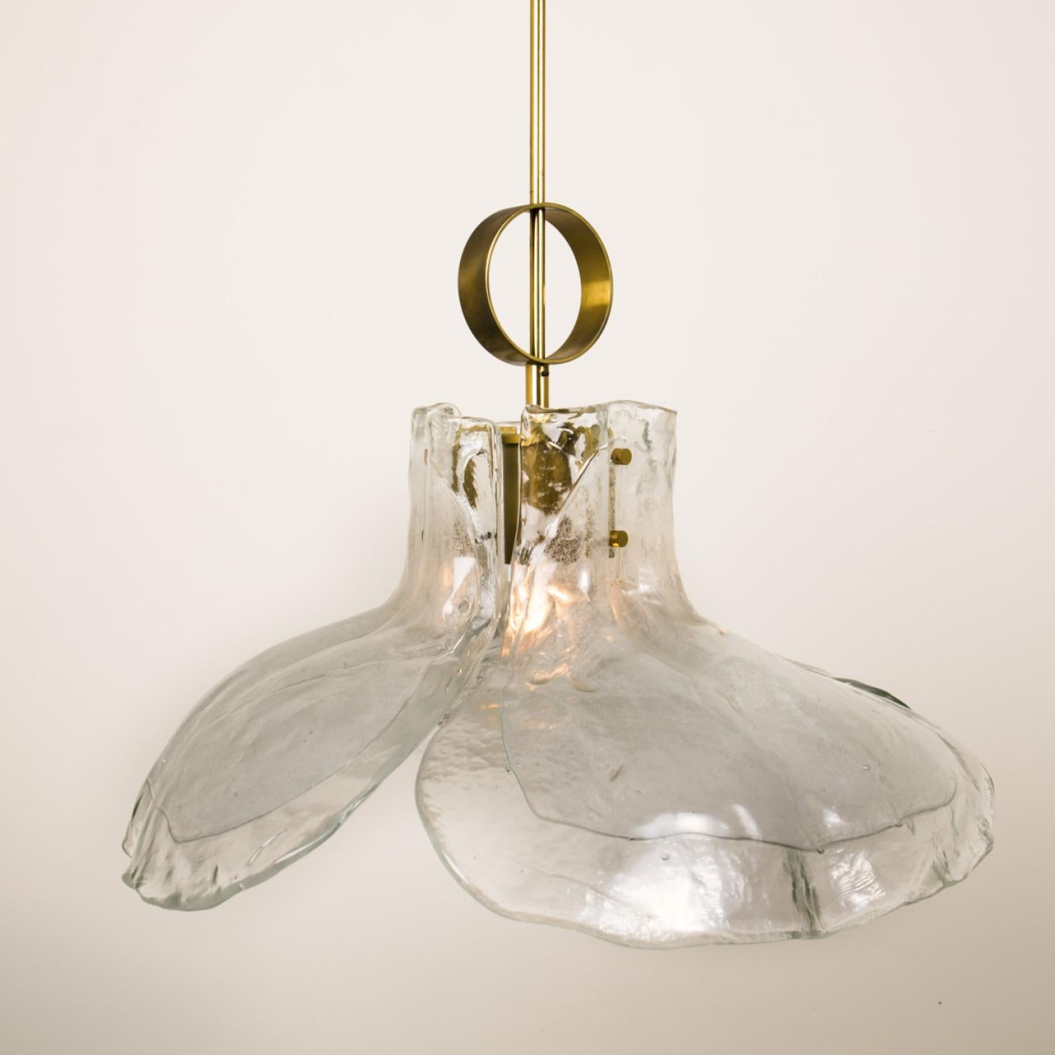 A beautiful midcentury brass chandelier with four melting glass panels in the shape of a flower.

Designed and executed by Kalmar Vienna in the 1970s. Hand blown melting glass, made of clear glass. Has a very nice ornamental ring on its brass rod.